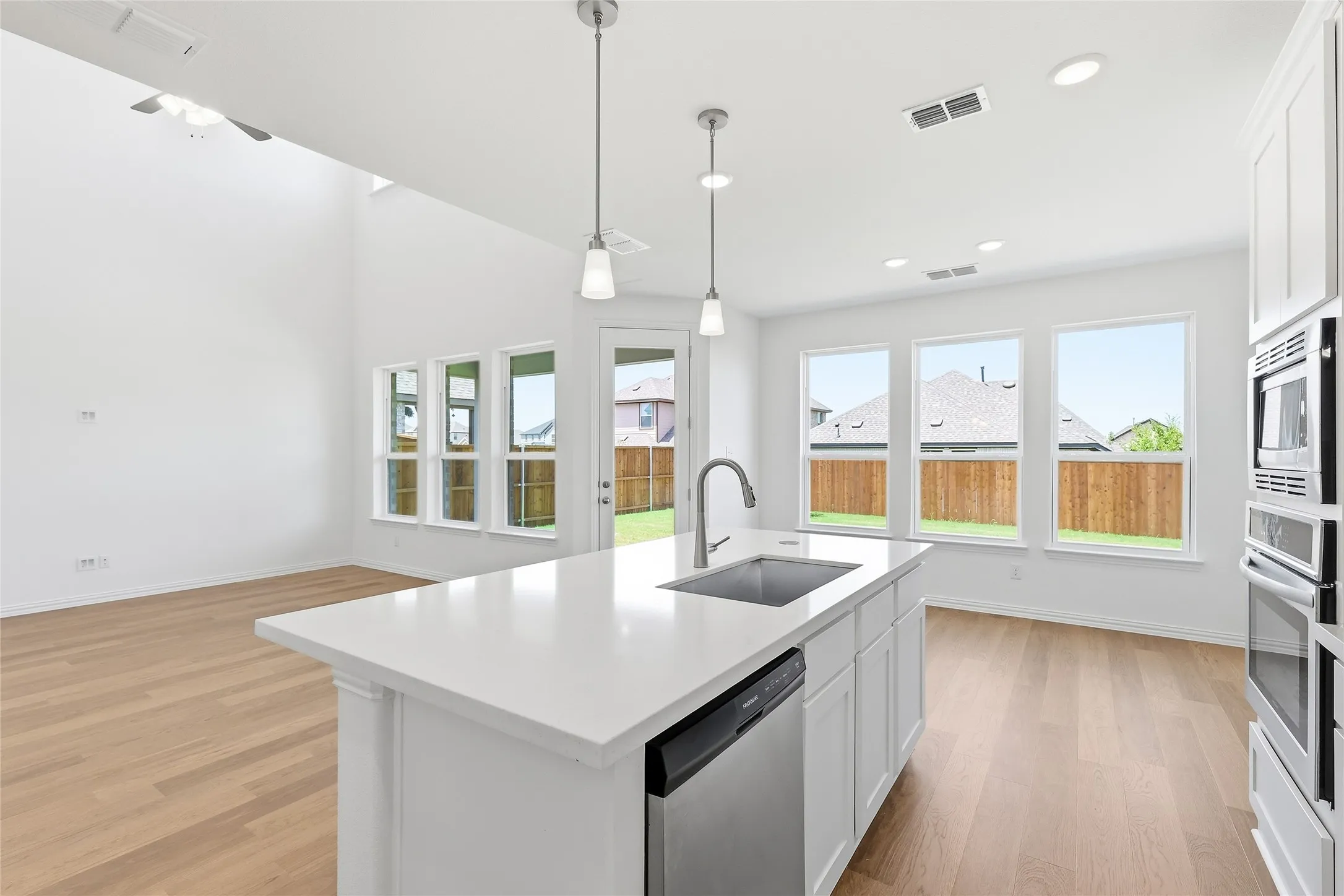 Kitchen island with a white solid surface countertop and undermount stainless steel sink