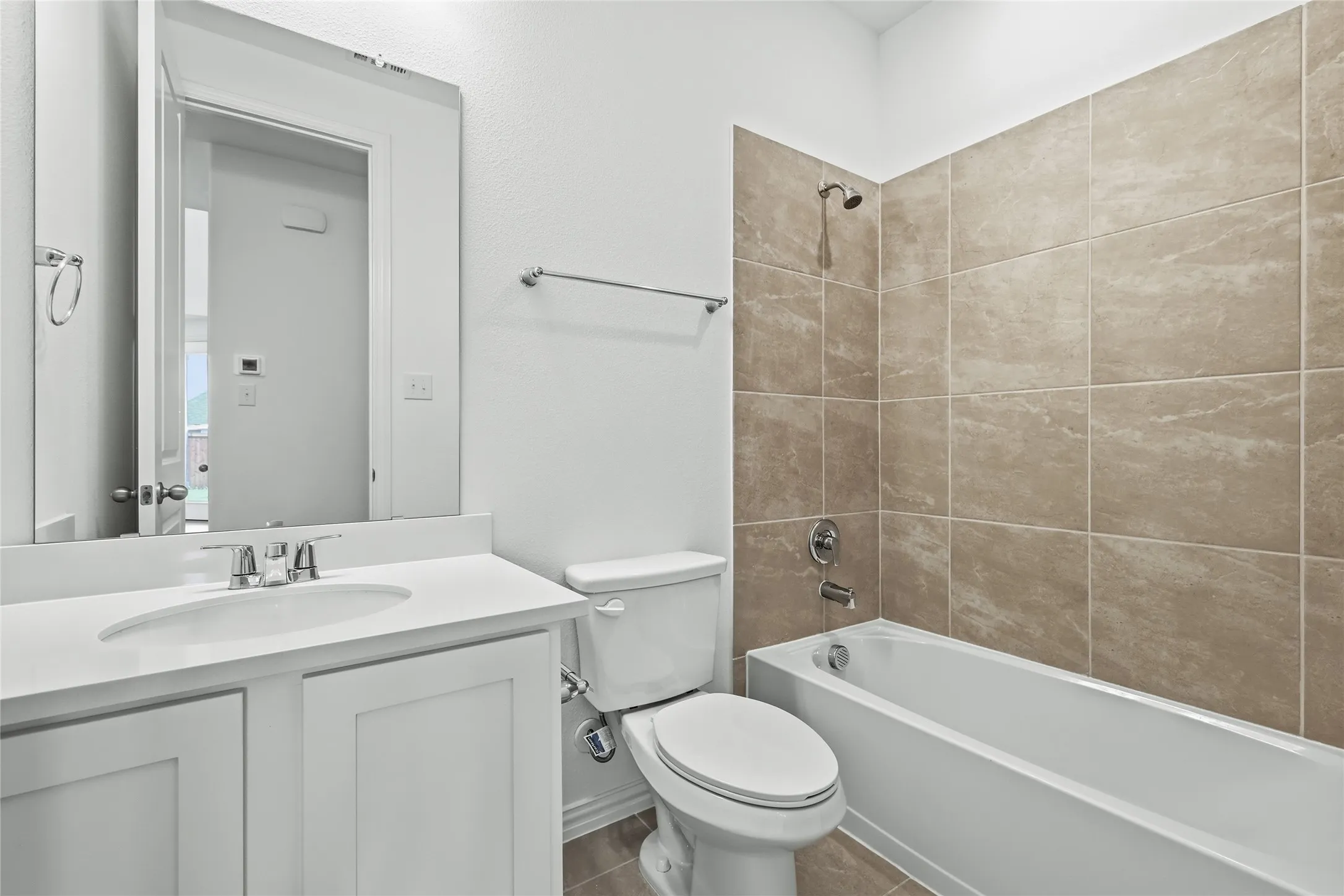 Bathroom featuring a white vanity with an integrated sink, polished chrome faucet, and a large mirror