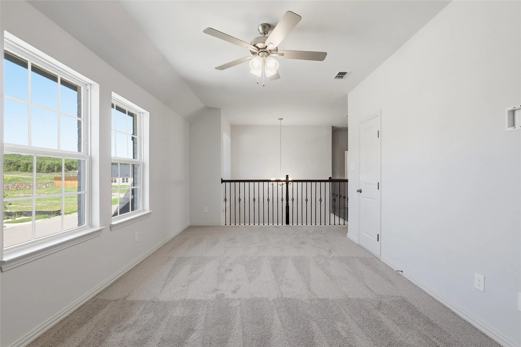 Spare room featuring a ceiling fan and light colored carpet
