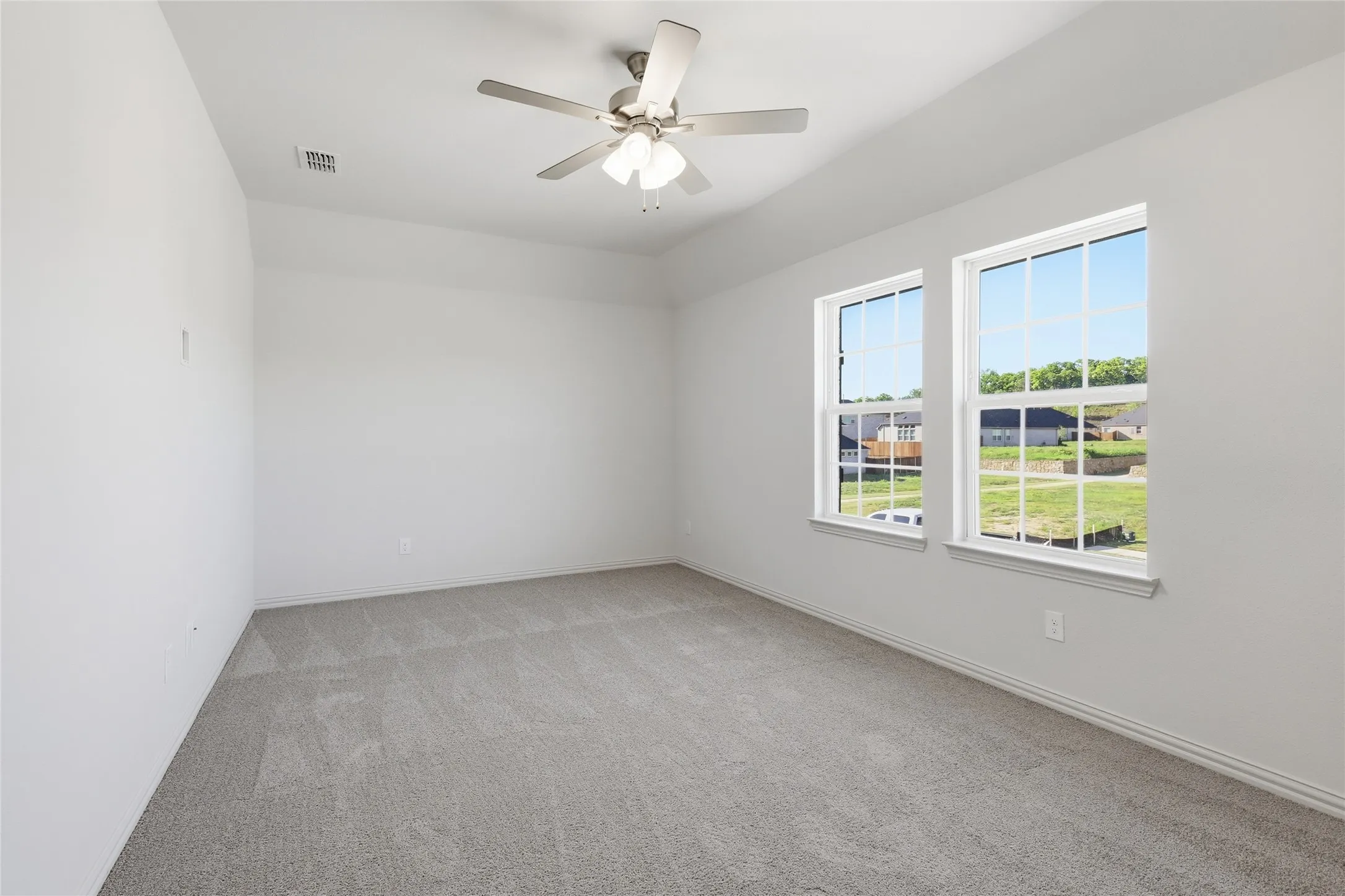 Spare room with light colored carpet and ceiling fan