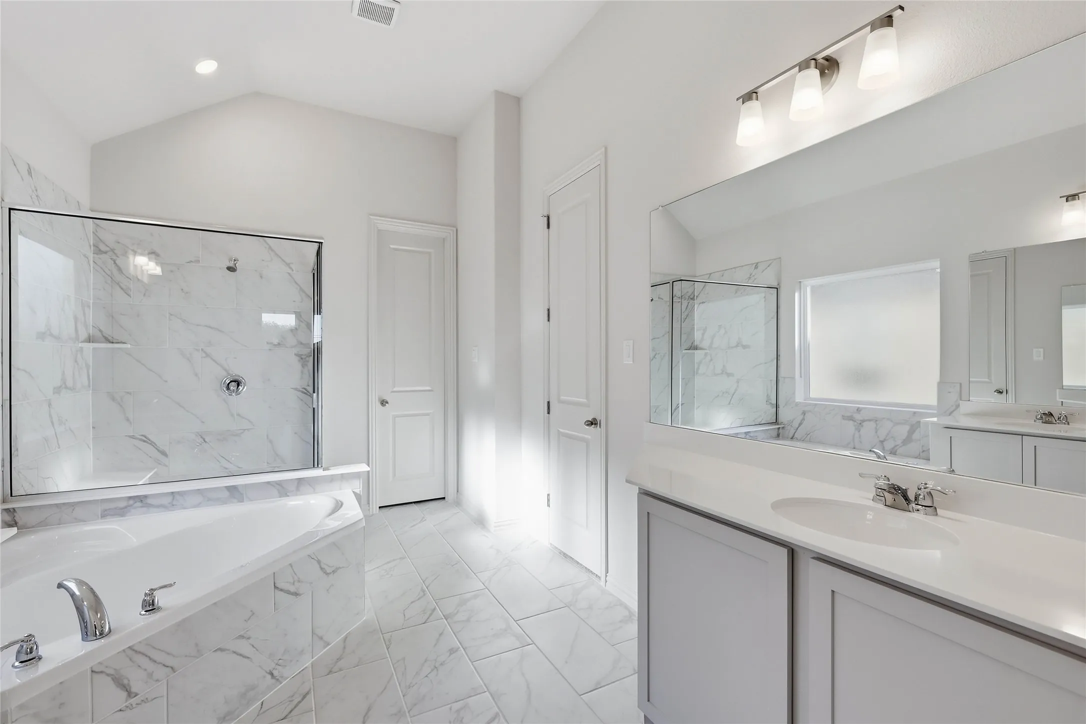 Full bath with a garden tub, light marble finish flooring, vanity, a marble finish shower, and vaulted ceiling