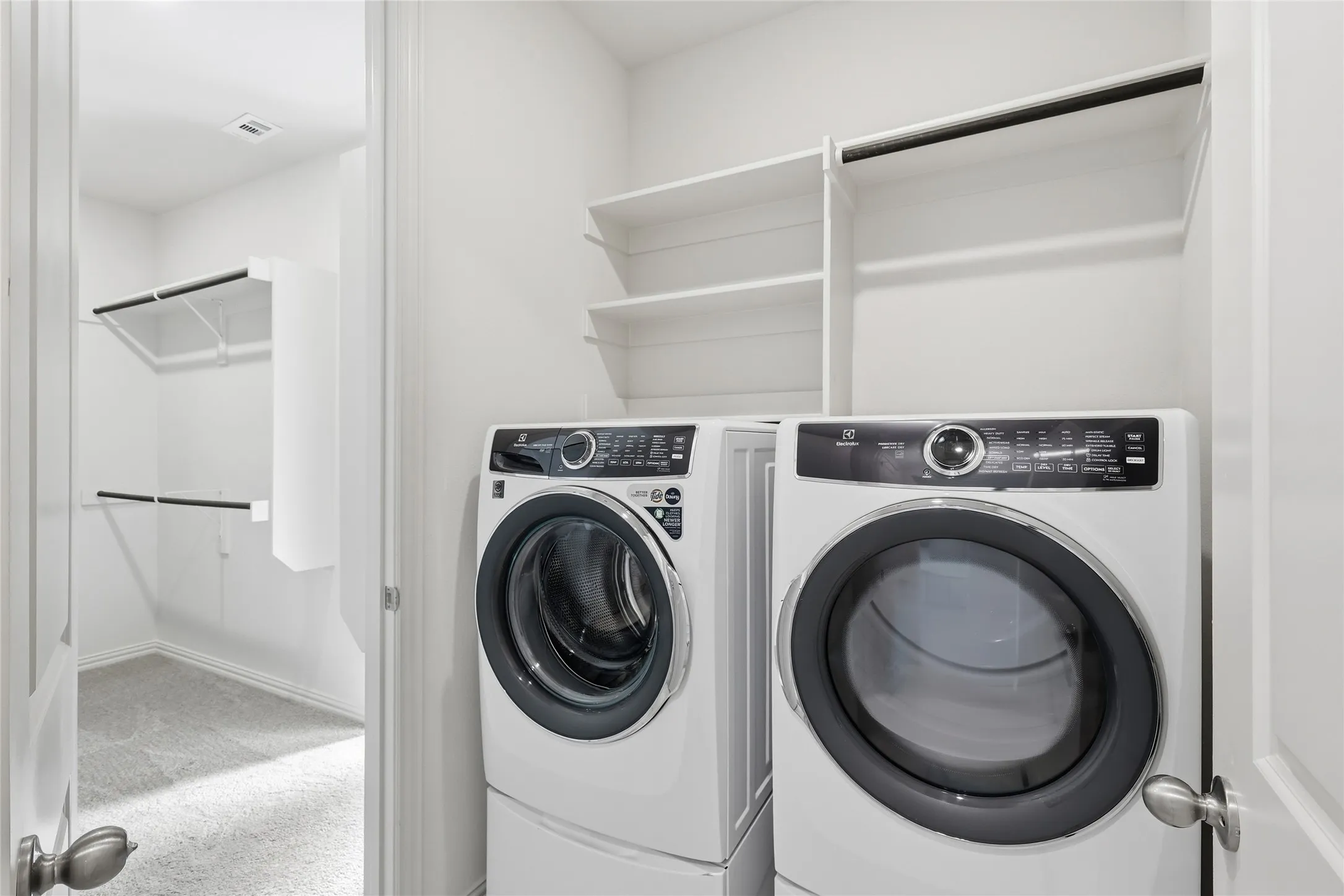 Laundry area with light colored carpet and washing machine and clothes dryer