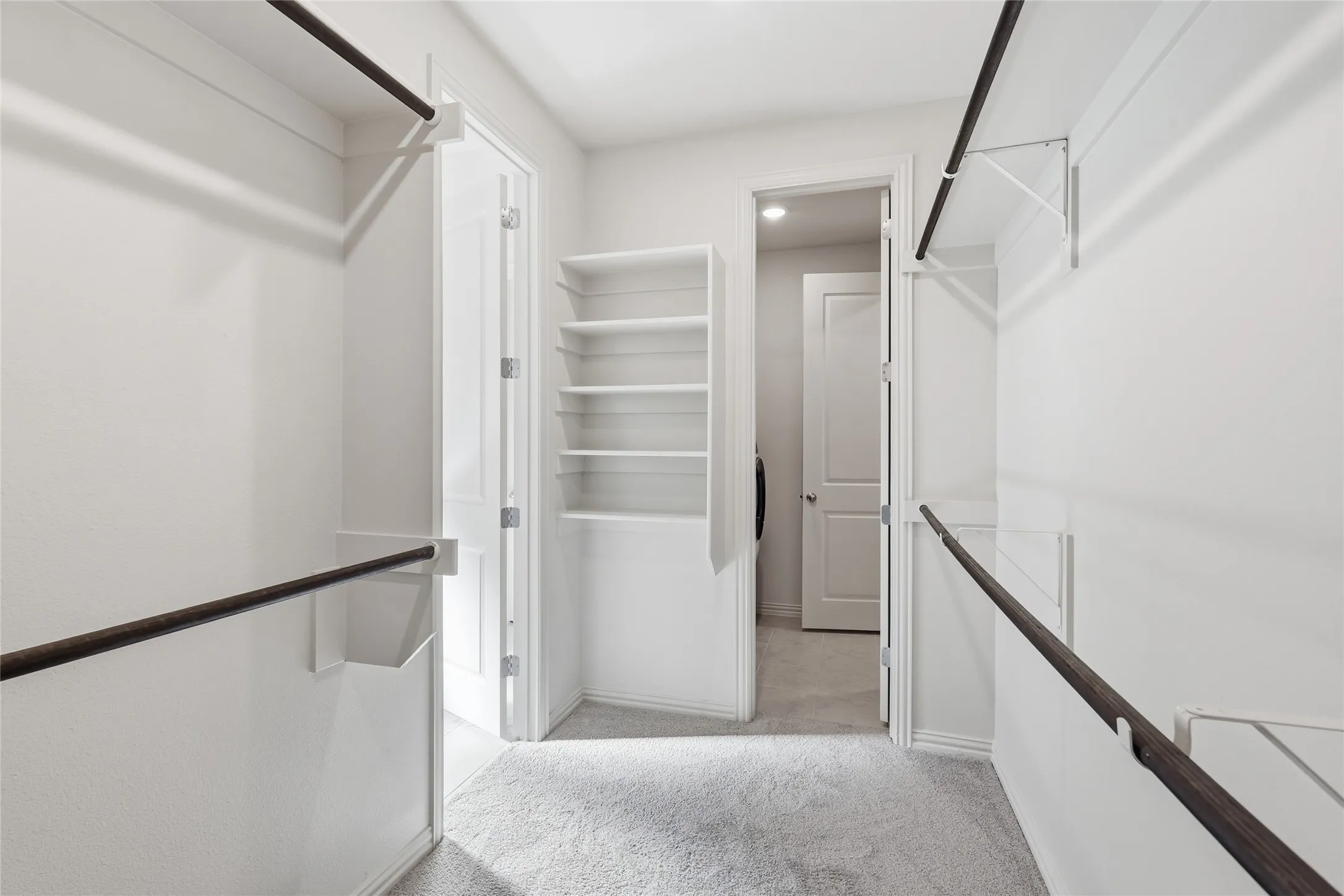 Walk in closet with light carpet