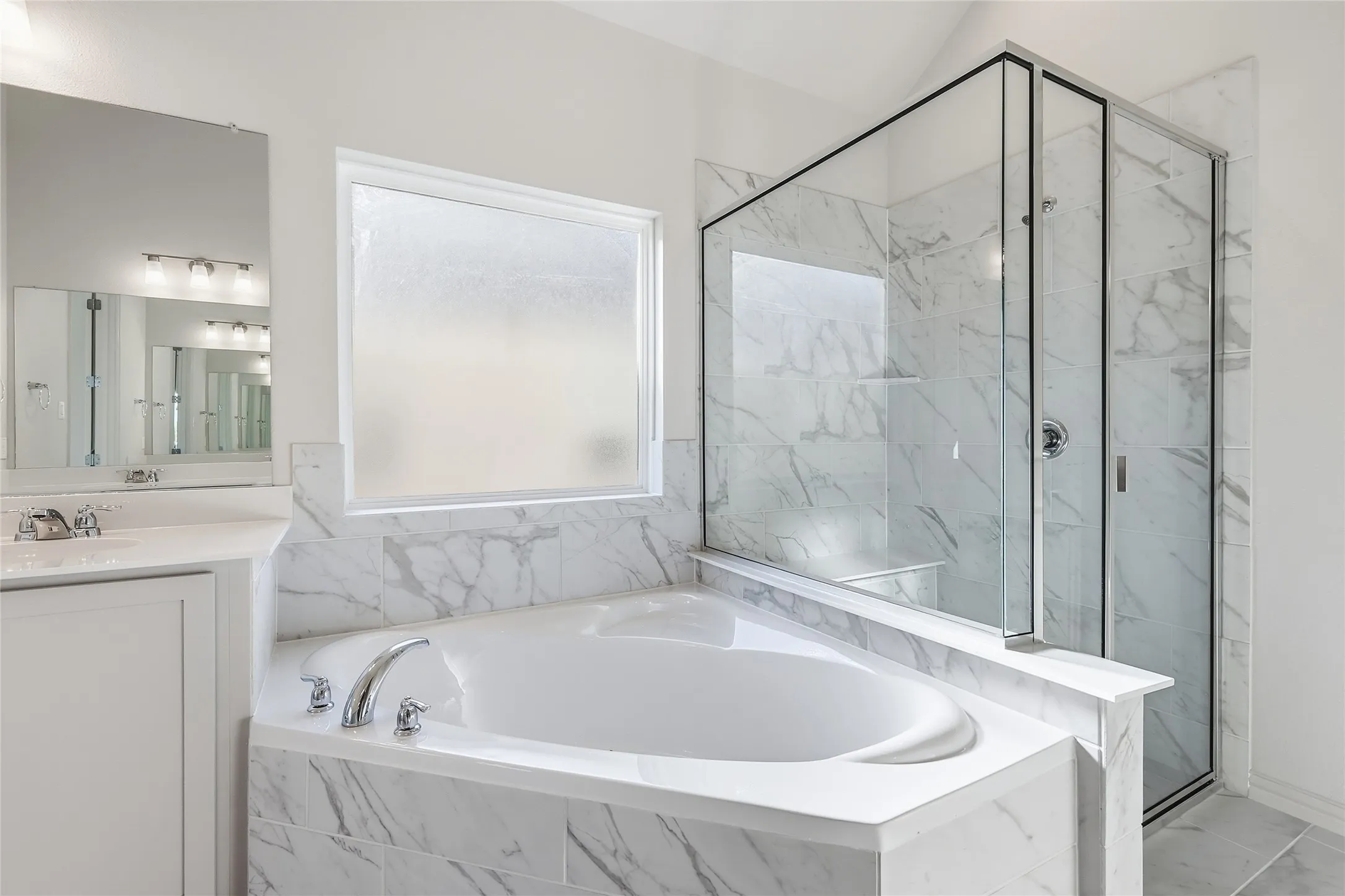Full bath featuring a marble finish shower, a bath, and vanity