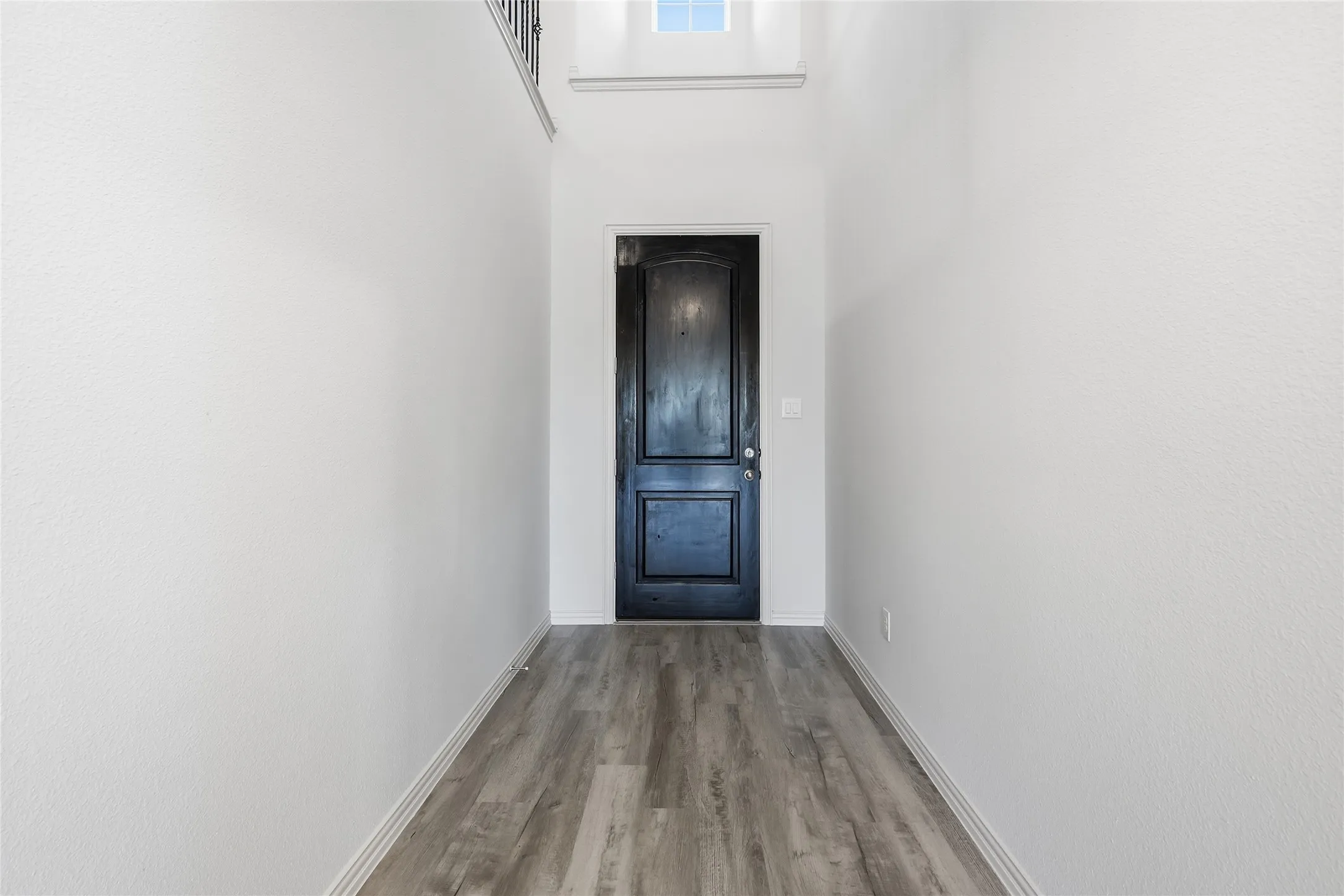 Entryway with wood finished floors and a high ceiling