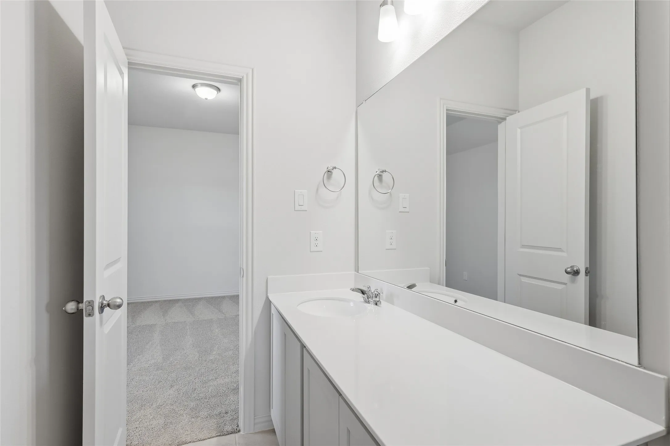 Bathroom featuring light colored carpet and vanity