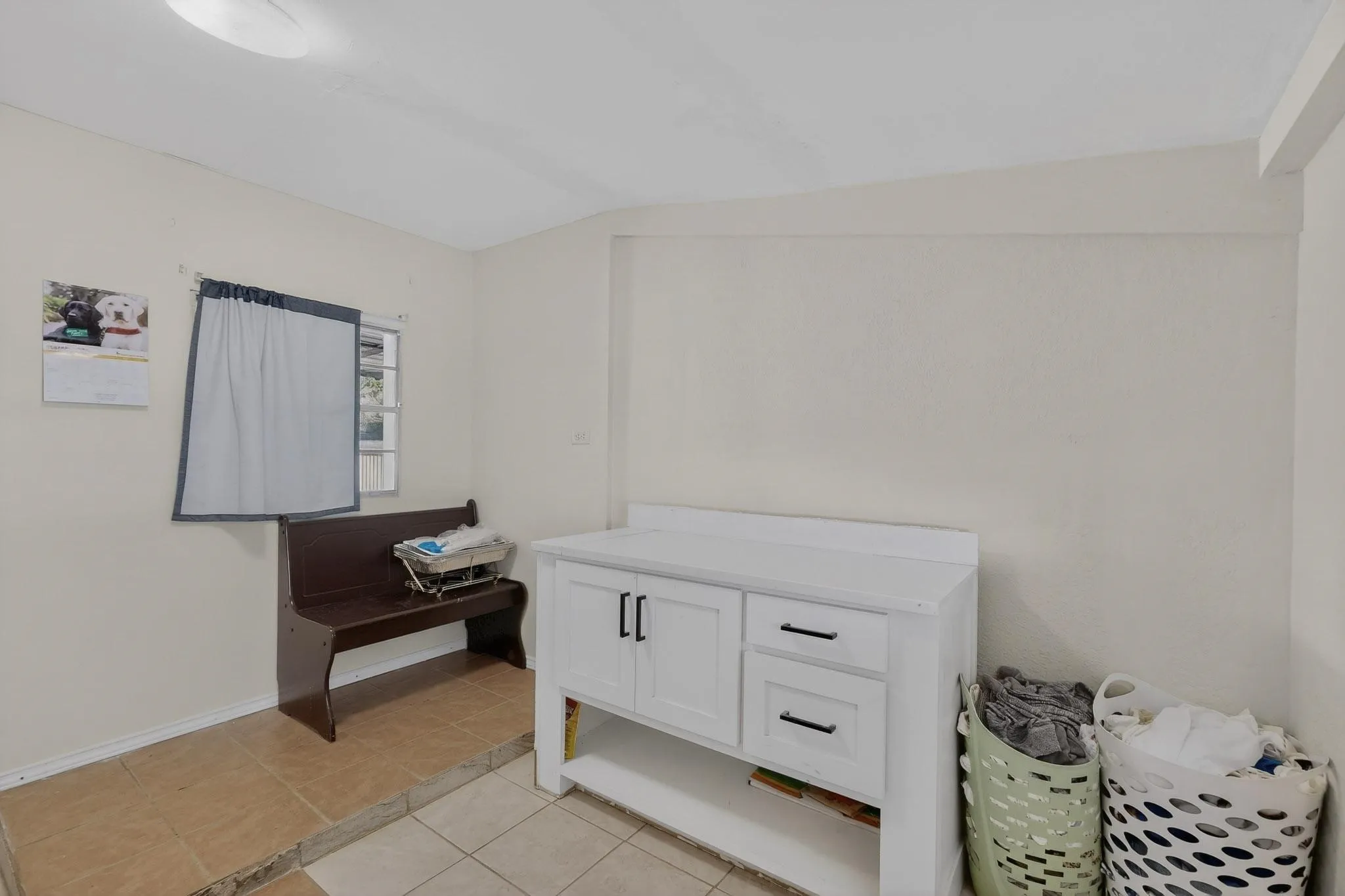 Bathroom with light tile patterned floors and vanity