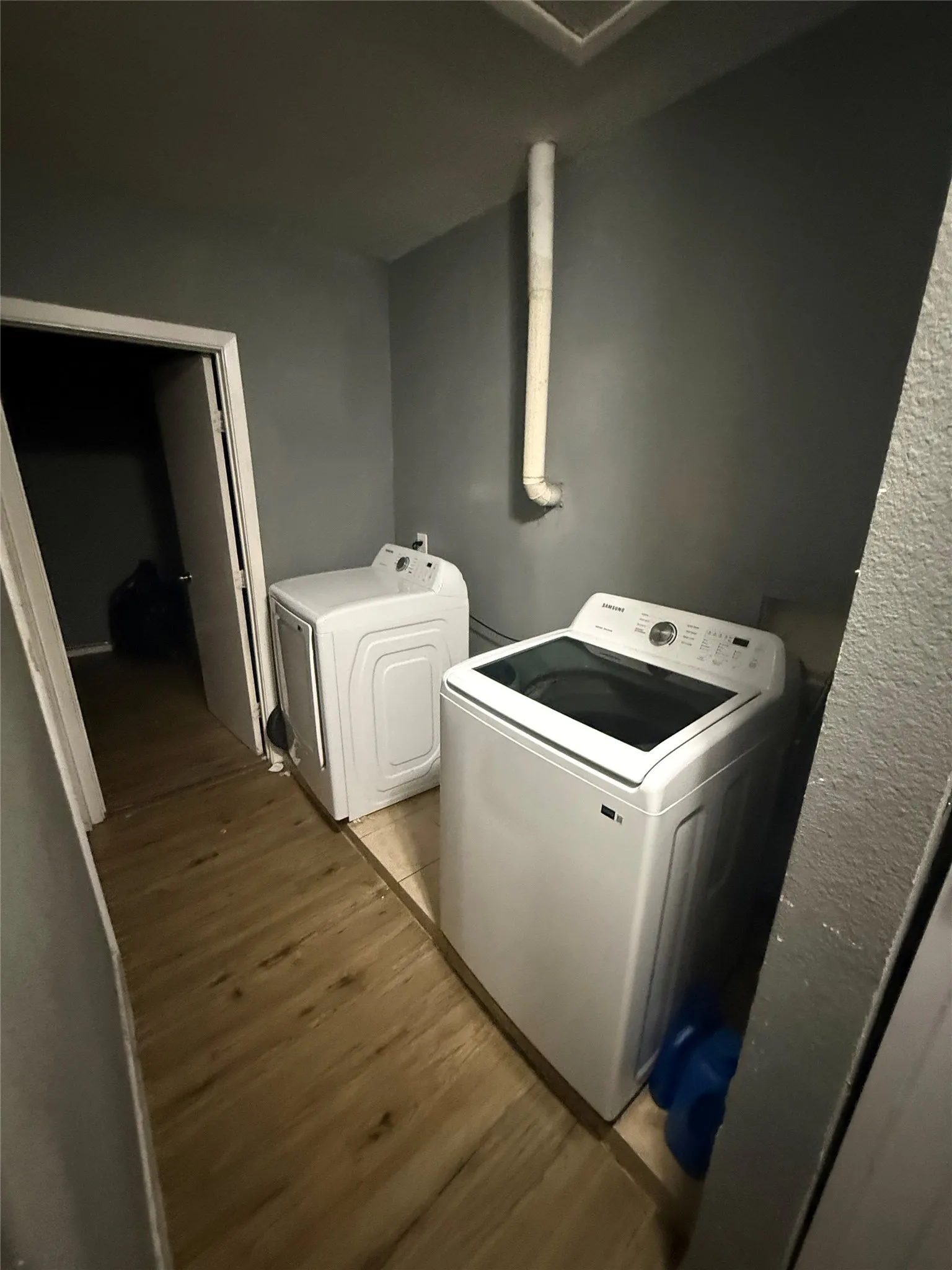Laundry room with light wood finished floors and washing machine and clothes dryer