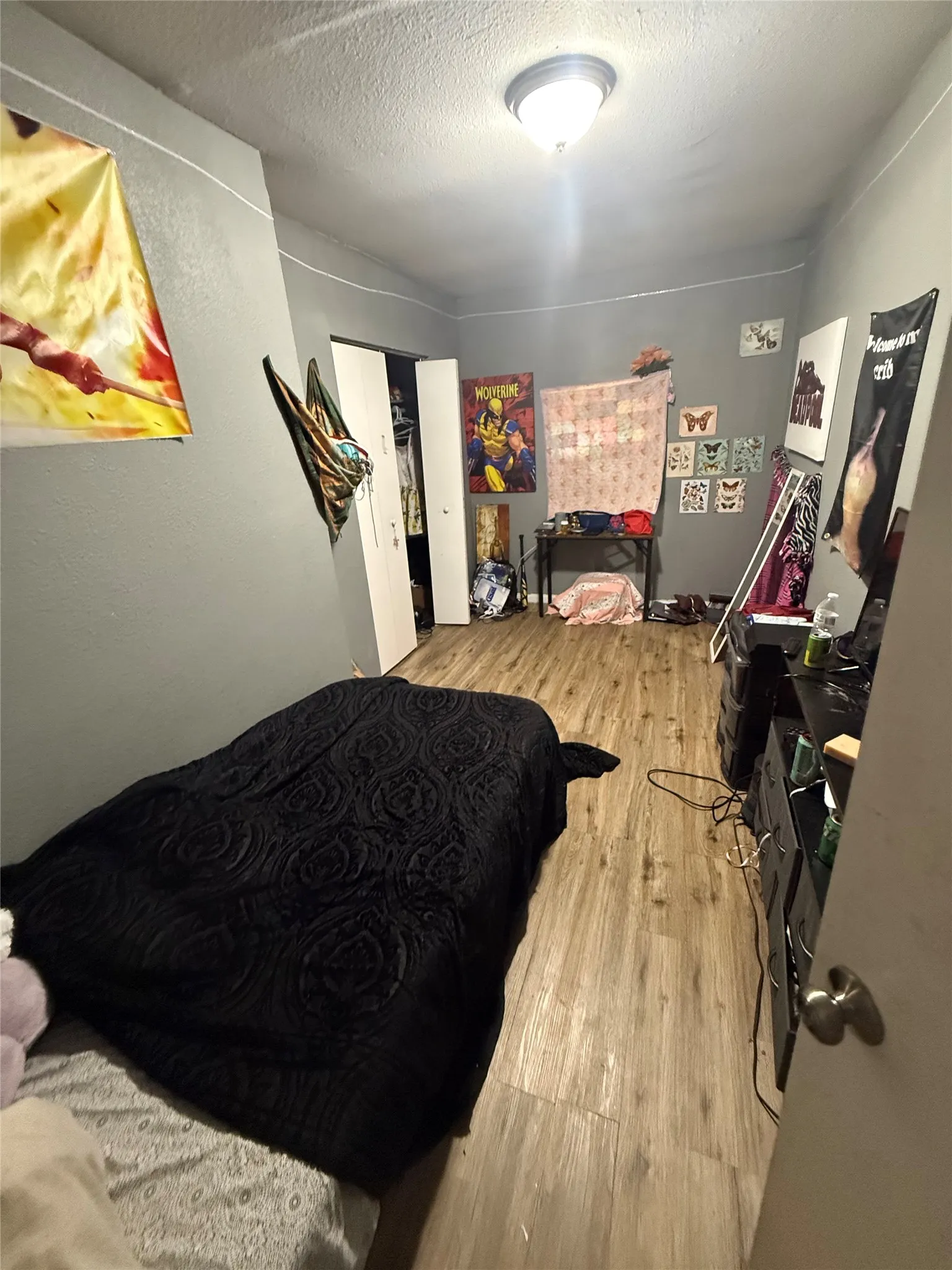 Bedroom with a textured ceiling and light wood-style floors