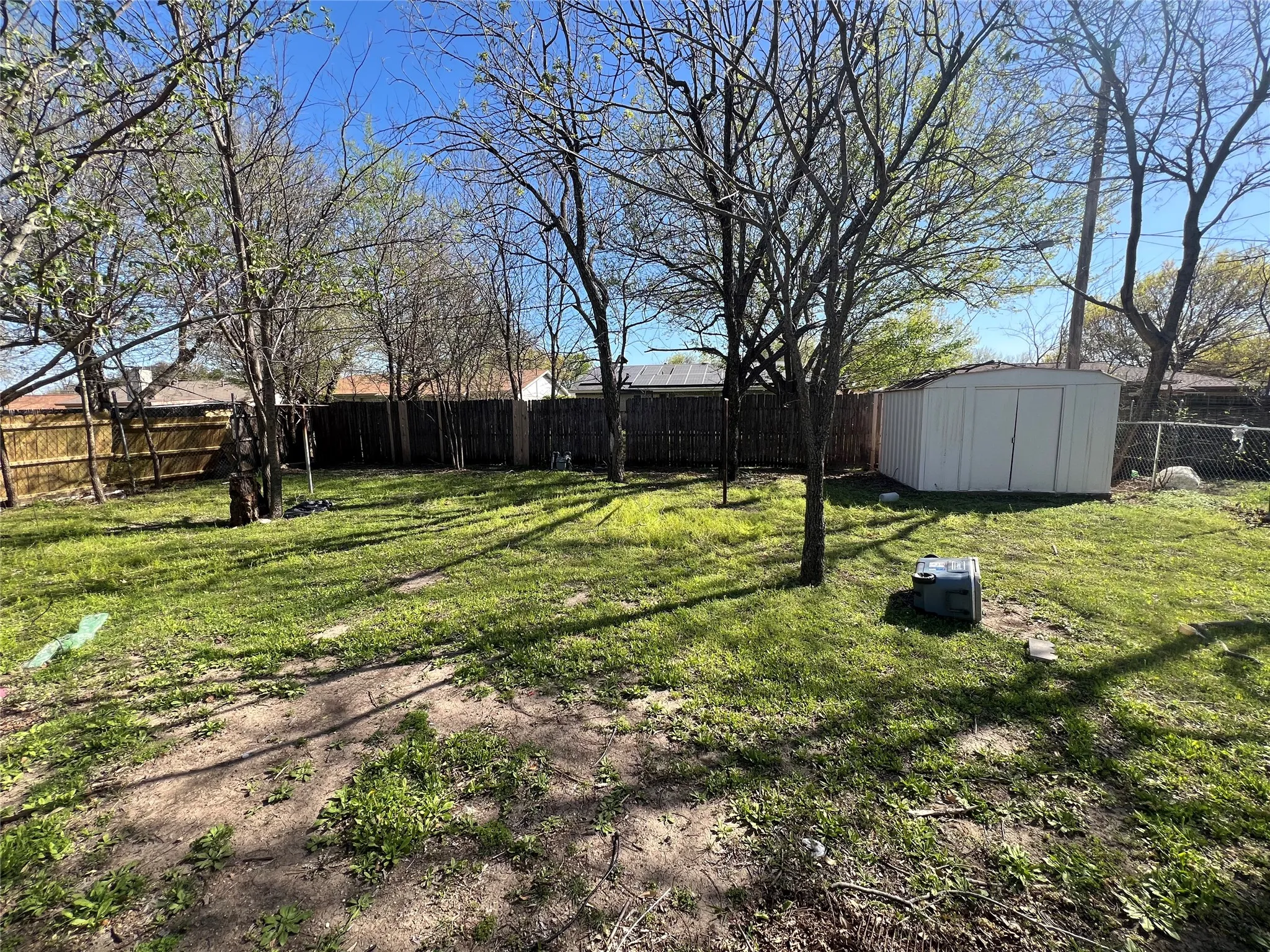 Fenced backyard with a storage unit