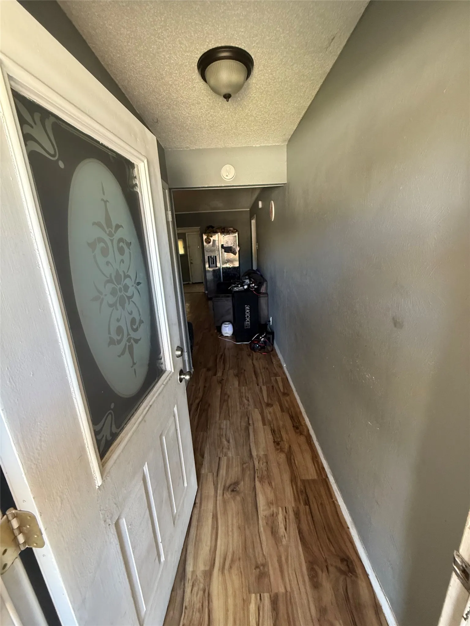 Corridor featuring a textured ceiling and dark wood-type flooring