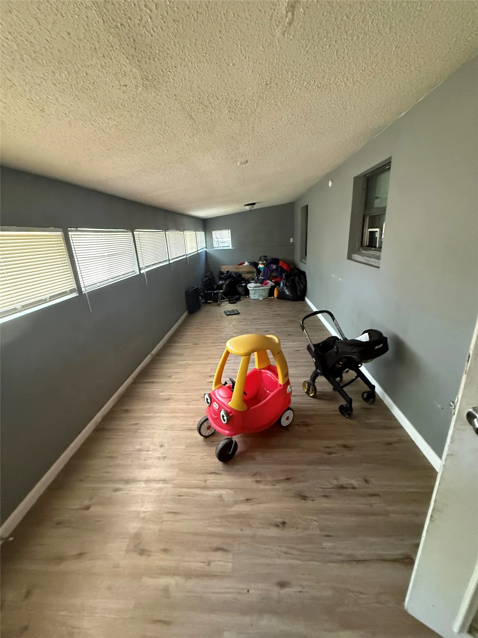 Playroom with light wood finished floors and a textured ceiling