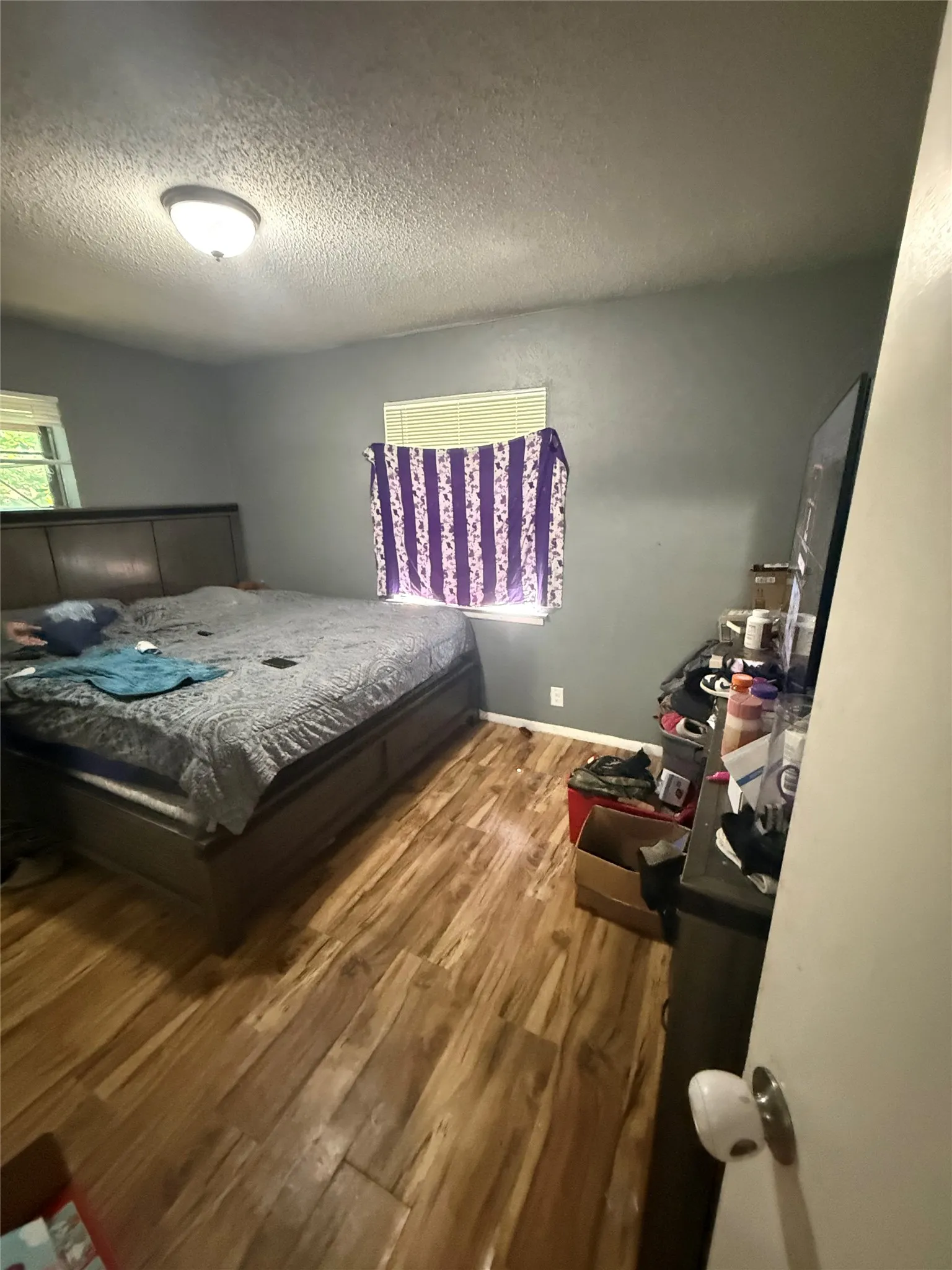 Bedroom with light wood finished floors and a textured ceiling