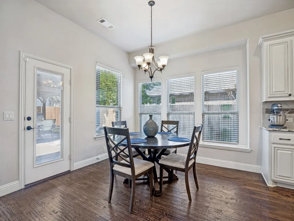 Dining room featuring dark wood-style floors and a chandelier