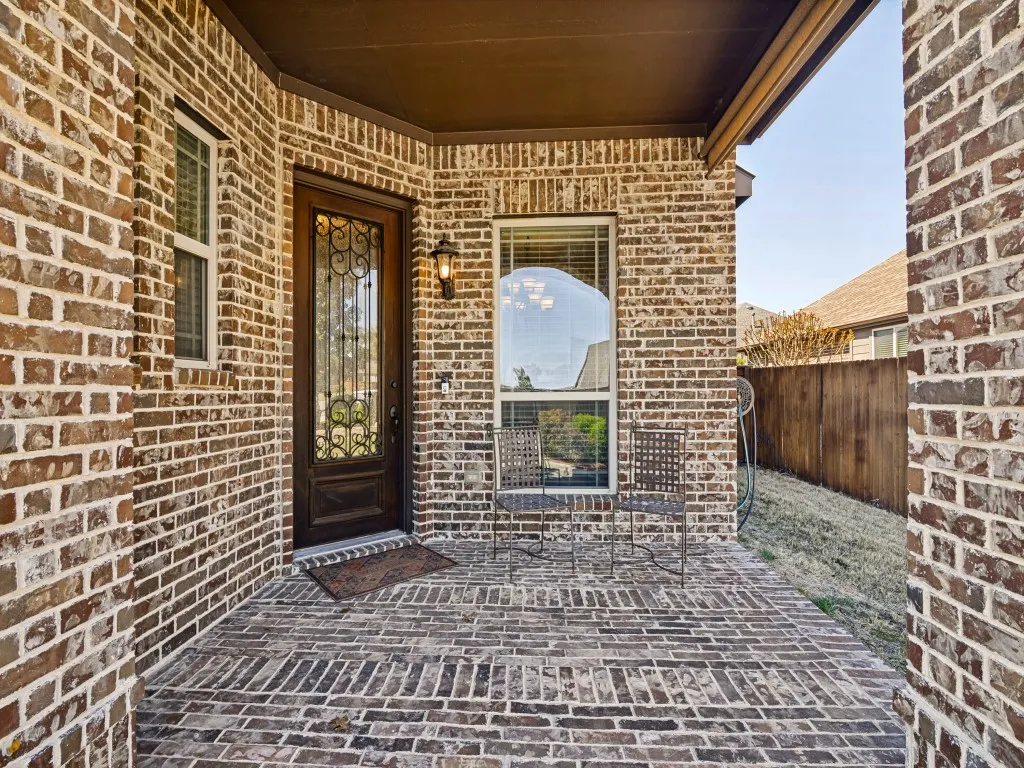 Doorway to property featuring brick siding
