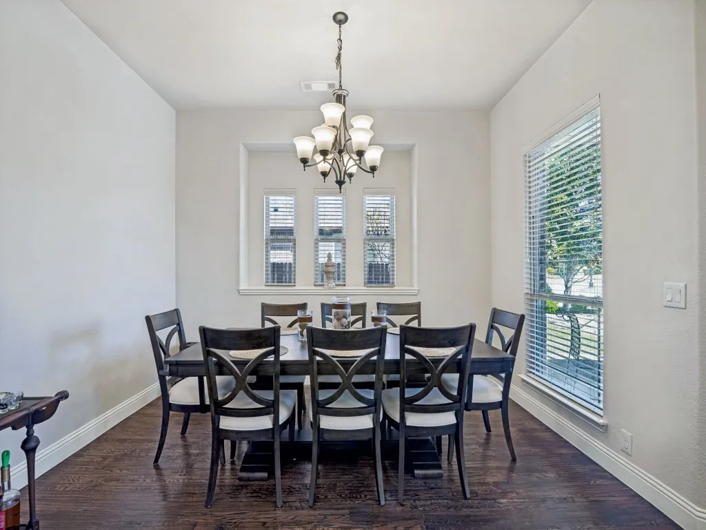 Dining area featuring dark wood finished floors and suspended lighting