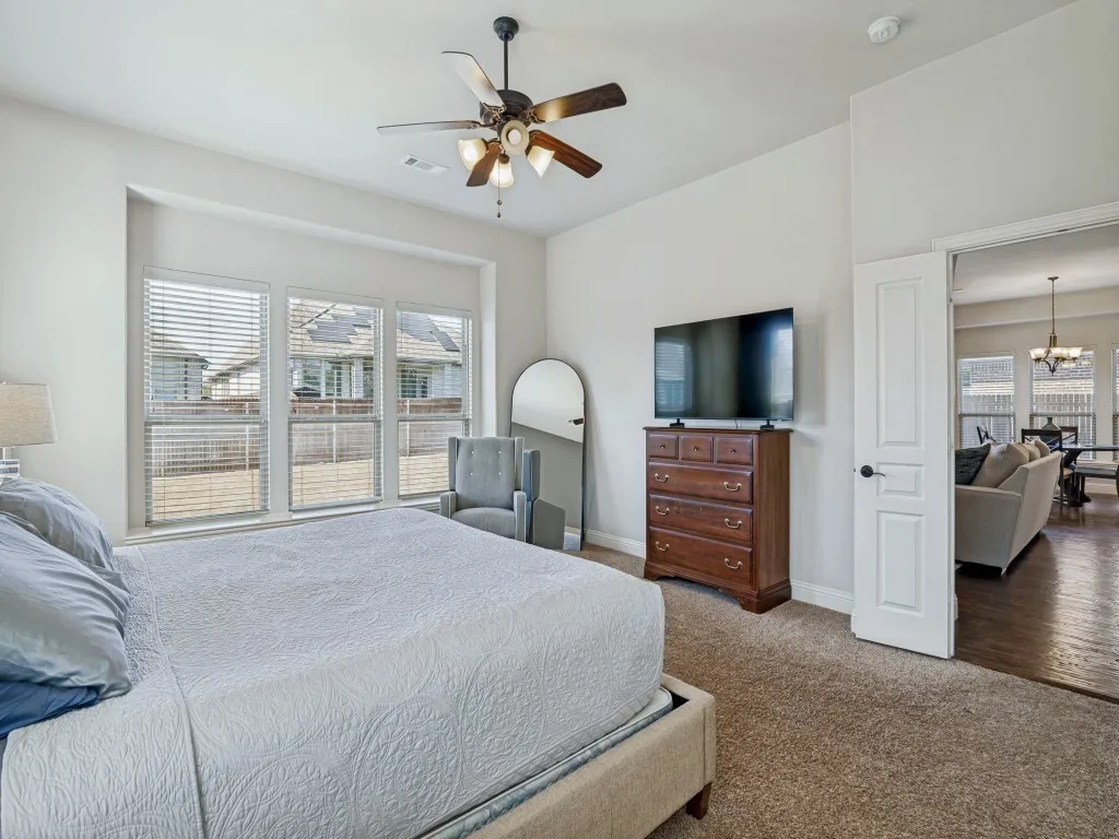 Bedroom featuring a chandelier, dark carpet, and a ceiling fan