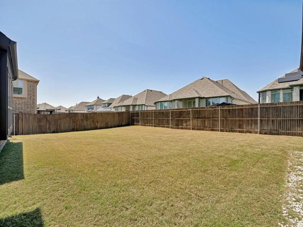 Fenced backyard featuring a residential view