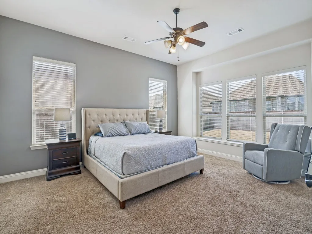 Carpeted bedroom with baseboards and ceiling fan