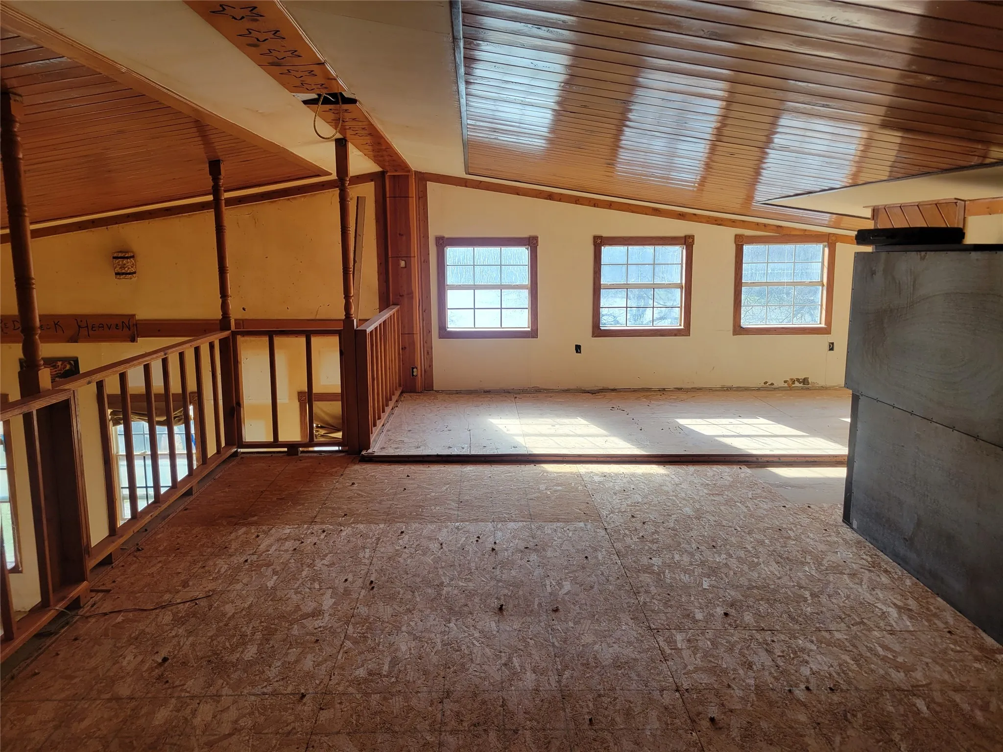 Unfurnished room with lofted ceiling