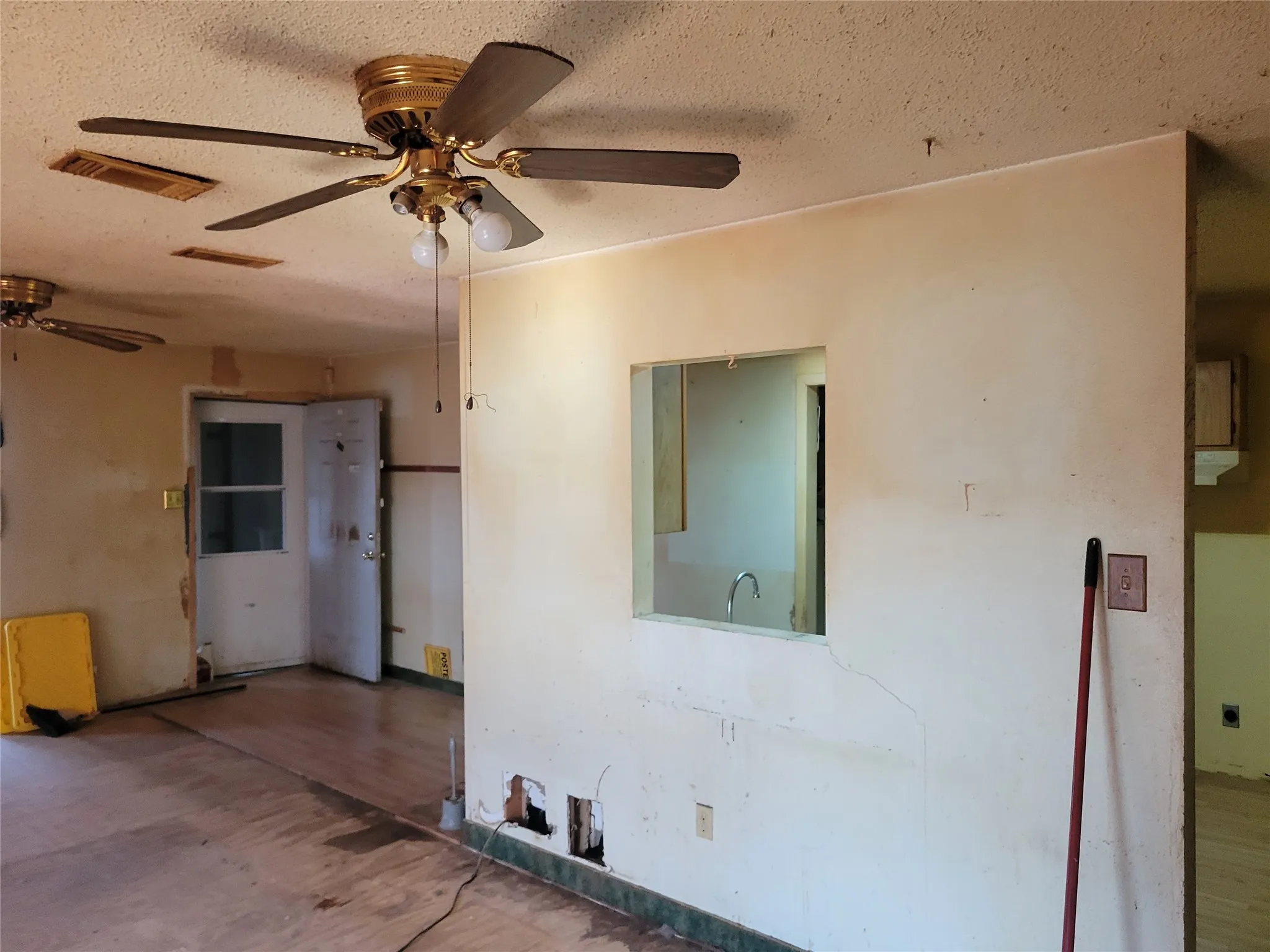 Unfurnished room featuring wood finished floors, a textured ceiling, and a ceiling fan