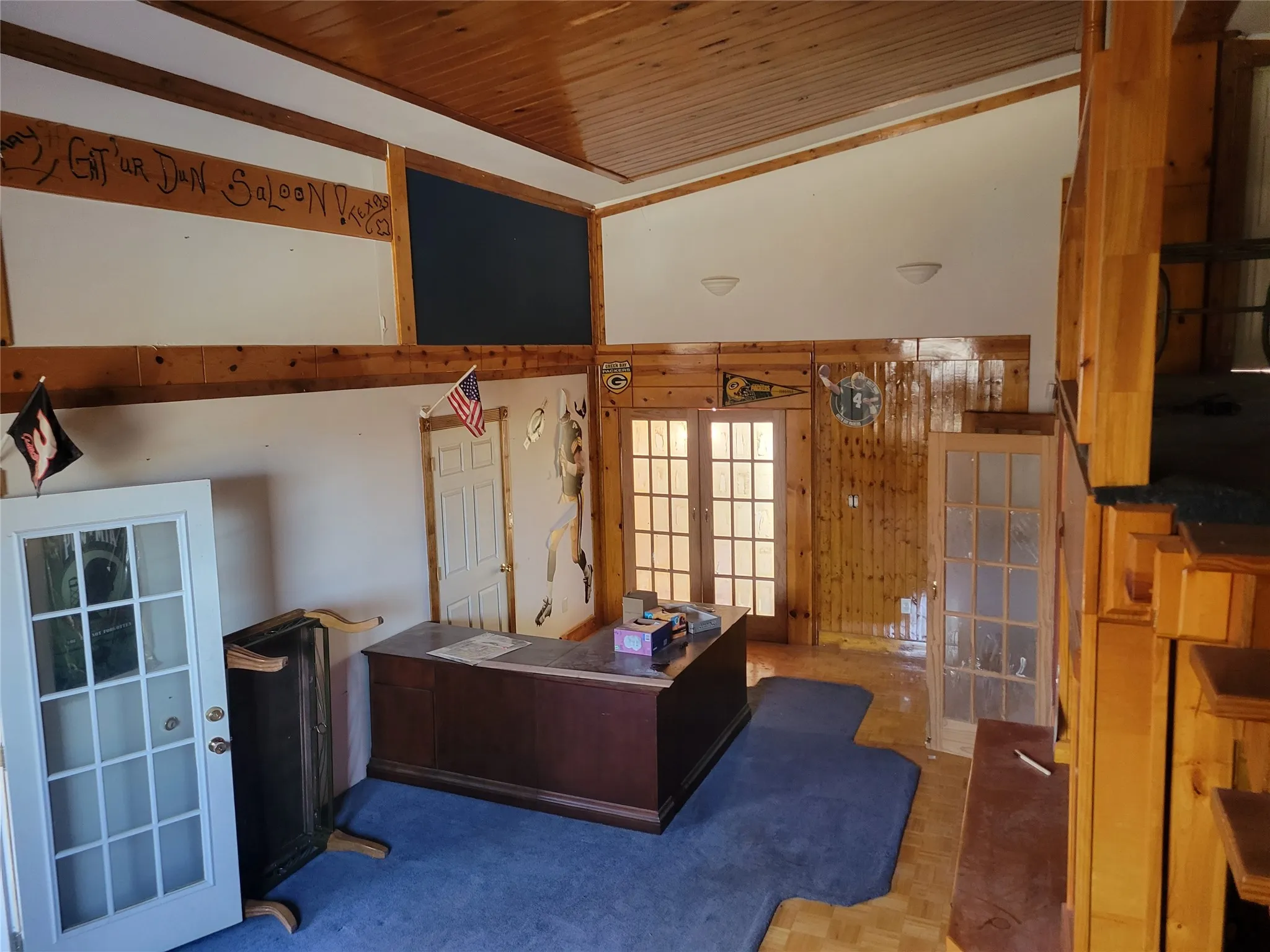 Office featuring a high wood ceiling, french doors, wood walls, and parquet flooring