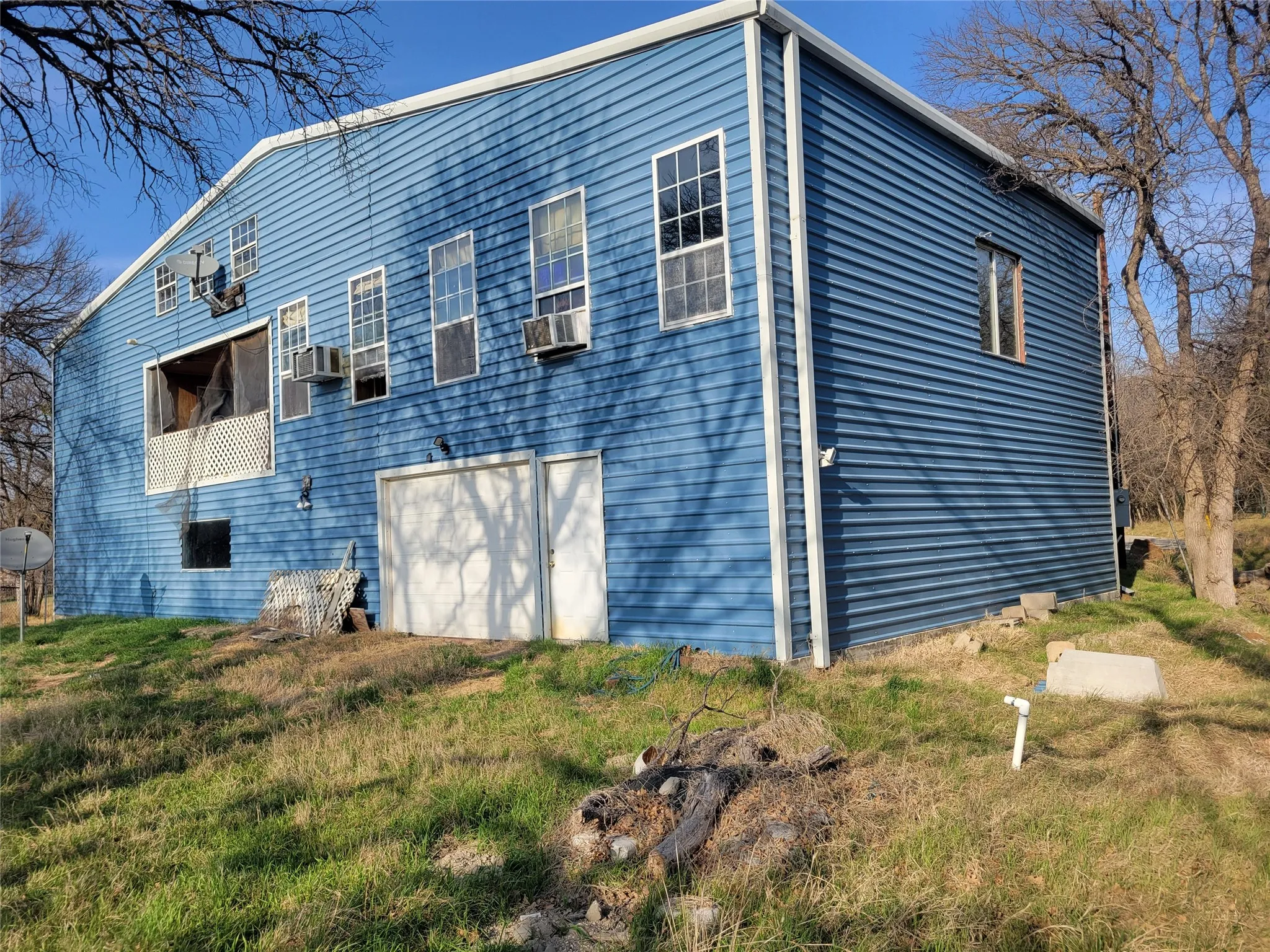 View of property exterior with a garage and a lawn