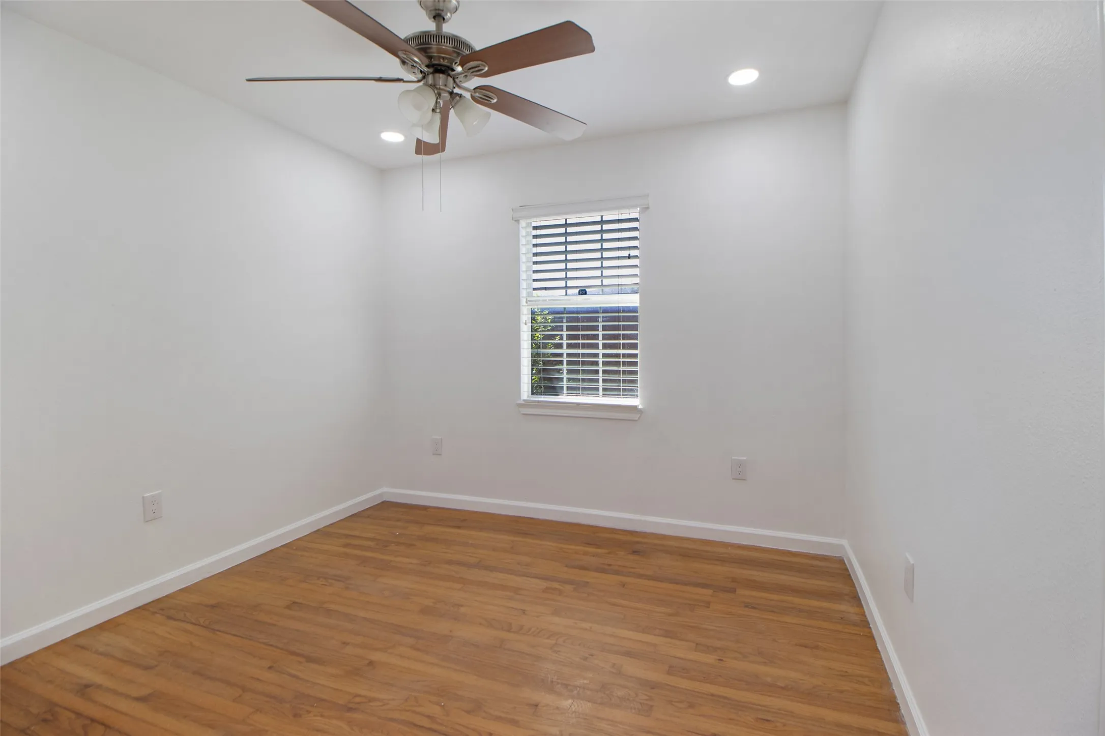 Bedroom with wood flooring, a ceiling fan, and recessed lighting