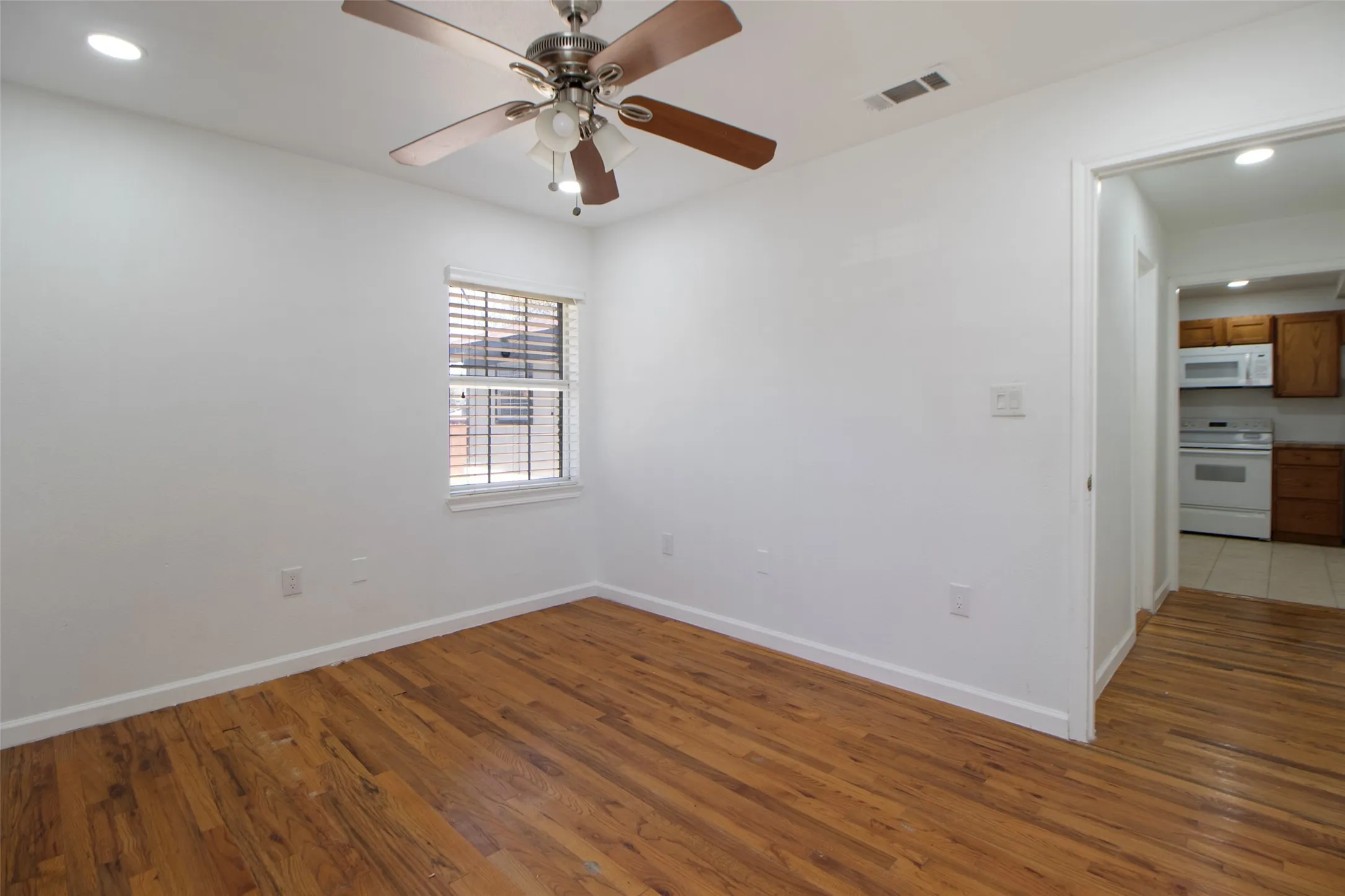 Bedroom with wood flooring, a ceiling fan, and recessed lighting