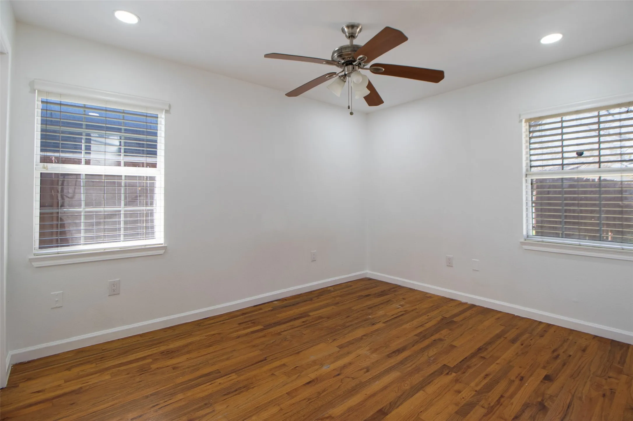 Bedroom with wood flooring, a ceiling fan, and recessed lighting