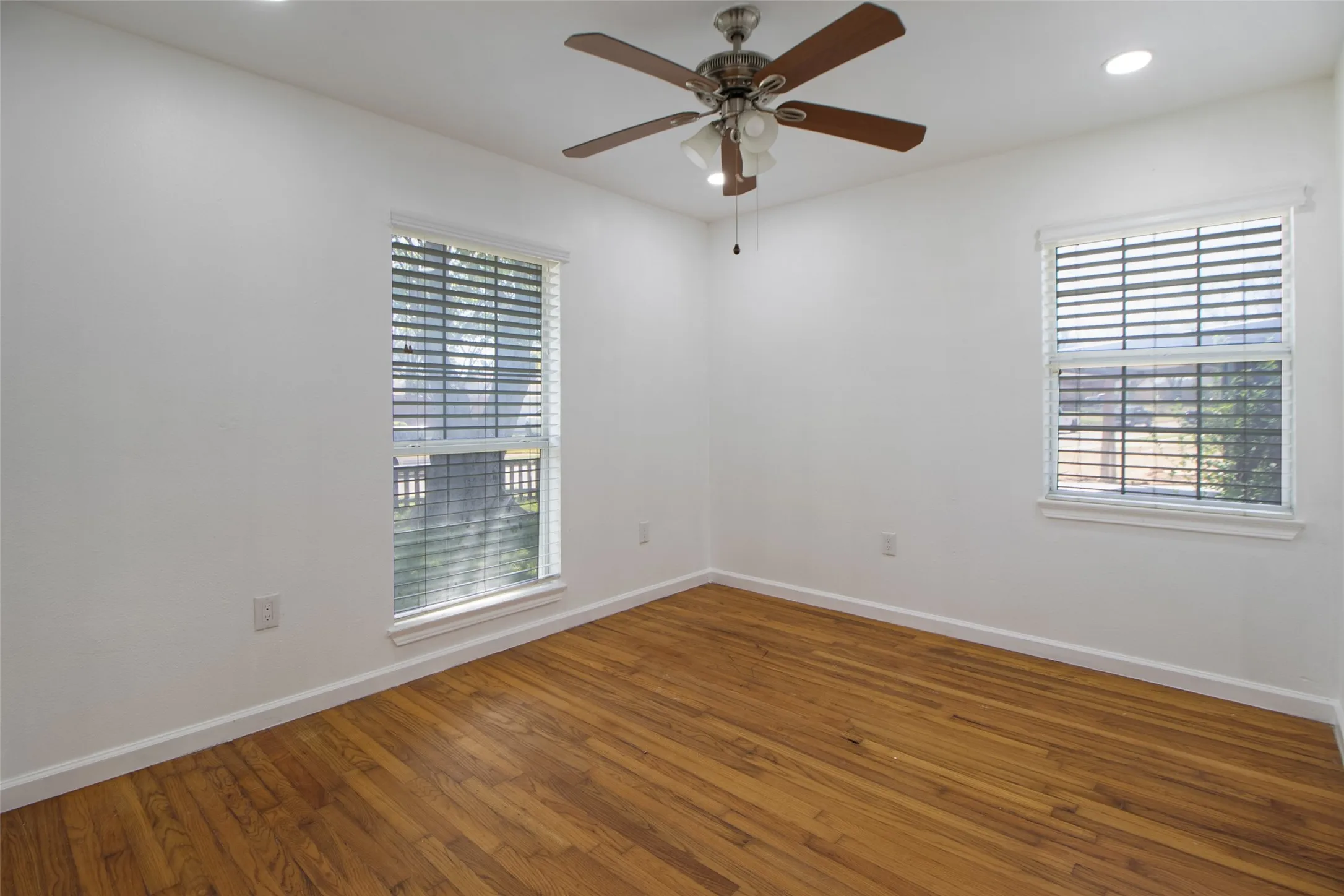 Unfurnished room with hardwood / wood-style floors, recessed lighting, ceiling fan, and healthy amount of natural light
