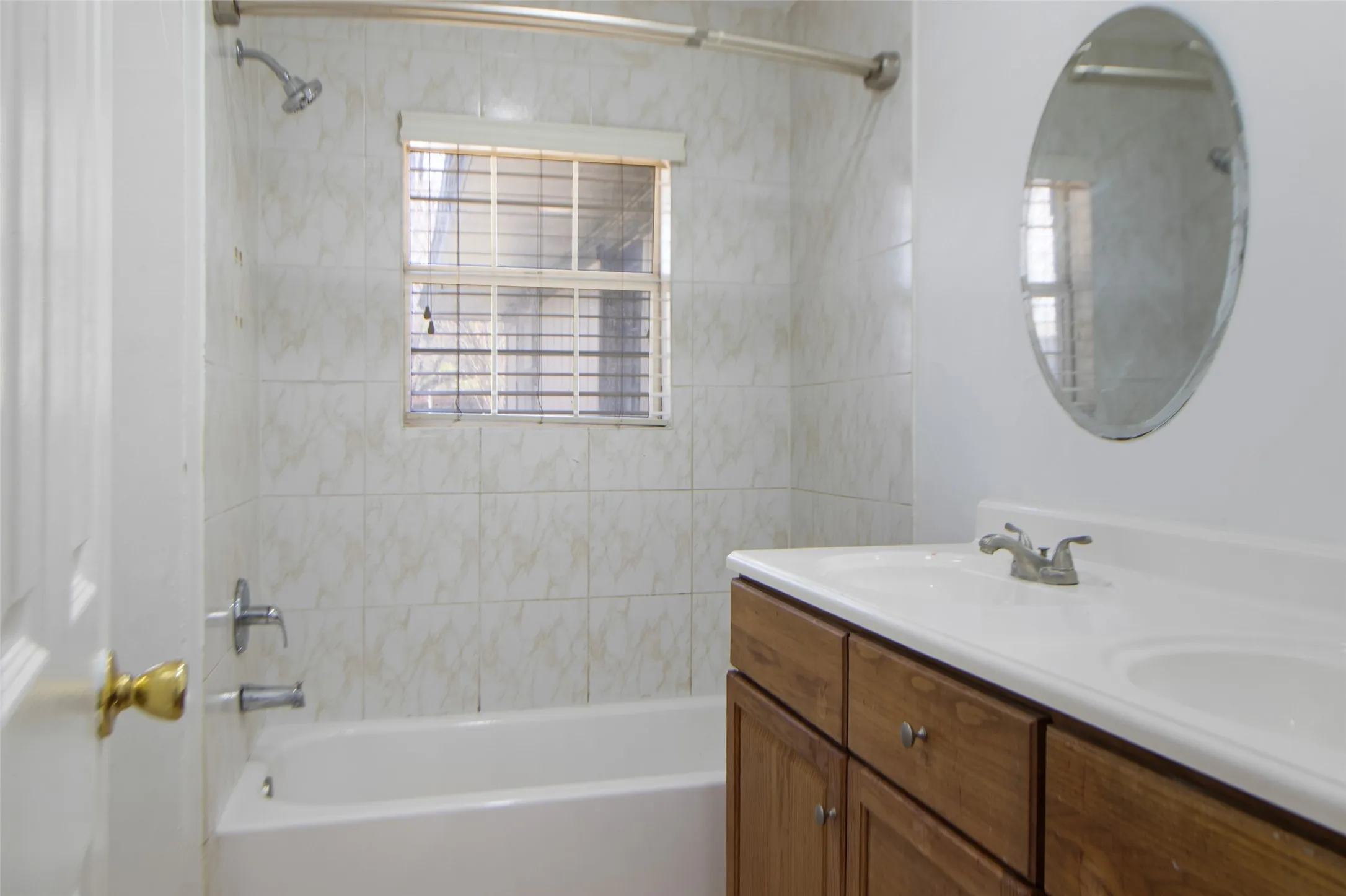 Bathroom with double vanity and bathtub / shower combination