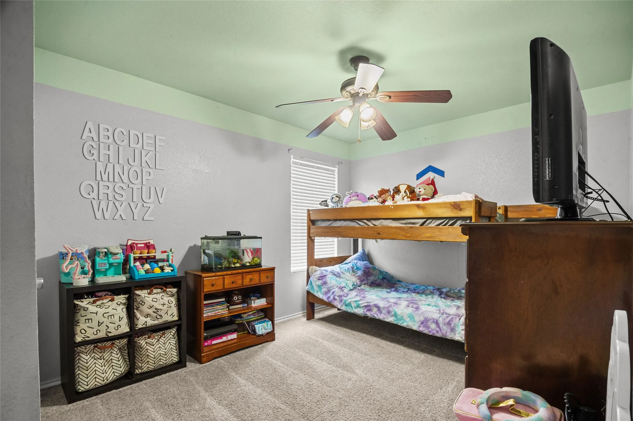 Carpeted bedroom featuring a ceiling fan and baseboards