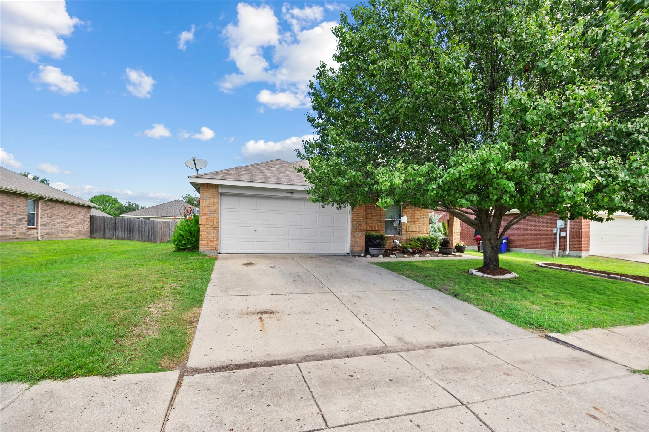 View of front of house with brick siding, an attached garage, and concrete driveway