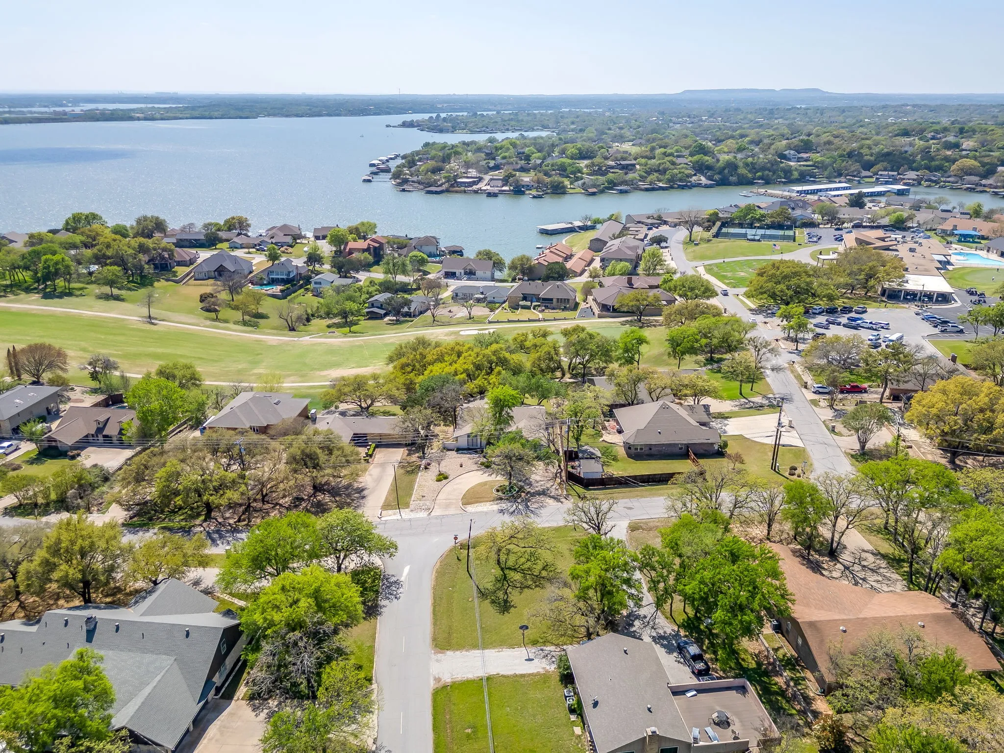 Looking at the front of the home with the circular driveway. This view shows how close the clubhouse is to the property. Just around the corner to the right of the property, you can see the parking lot and the pool behind the clubhouse.