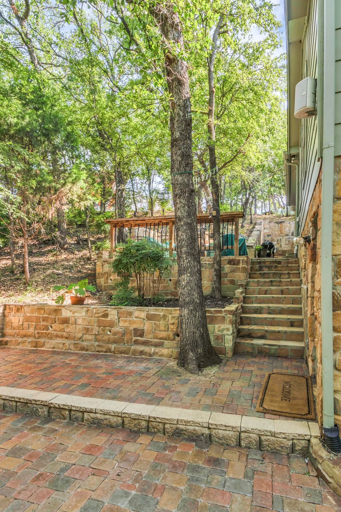 Multi-toned paver patio with a stone retaining wall and integrated stone steps