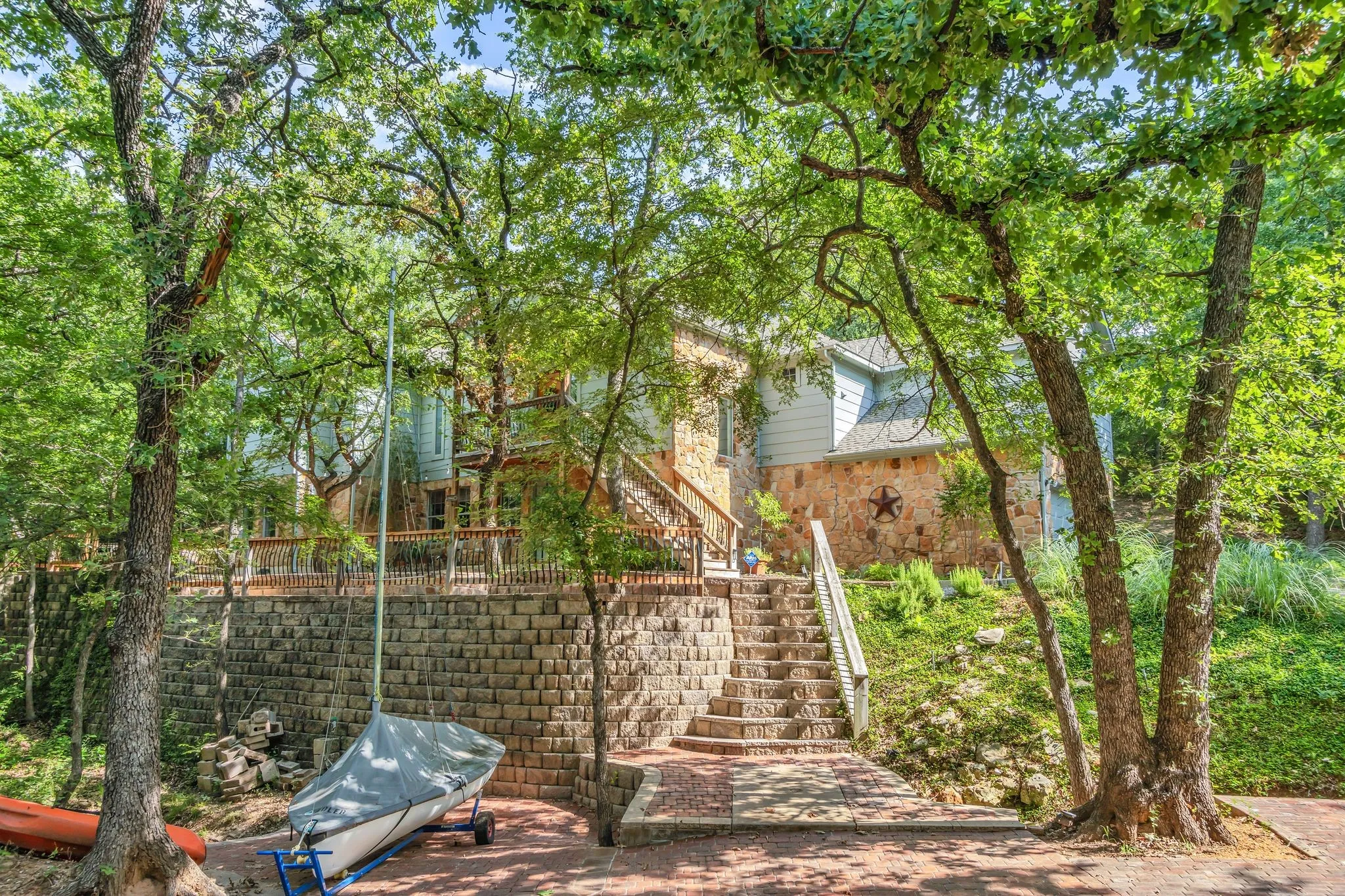 Tiered retaining walls supporting a multi-level property with a stone and siding exterior