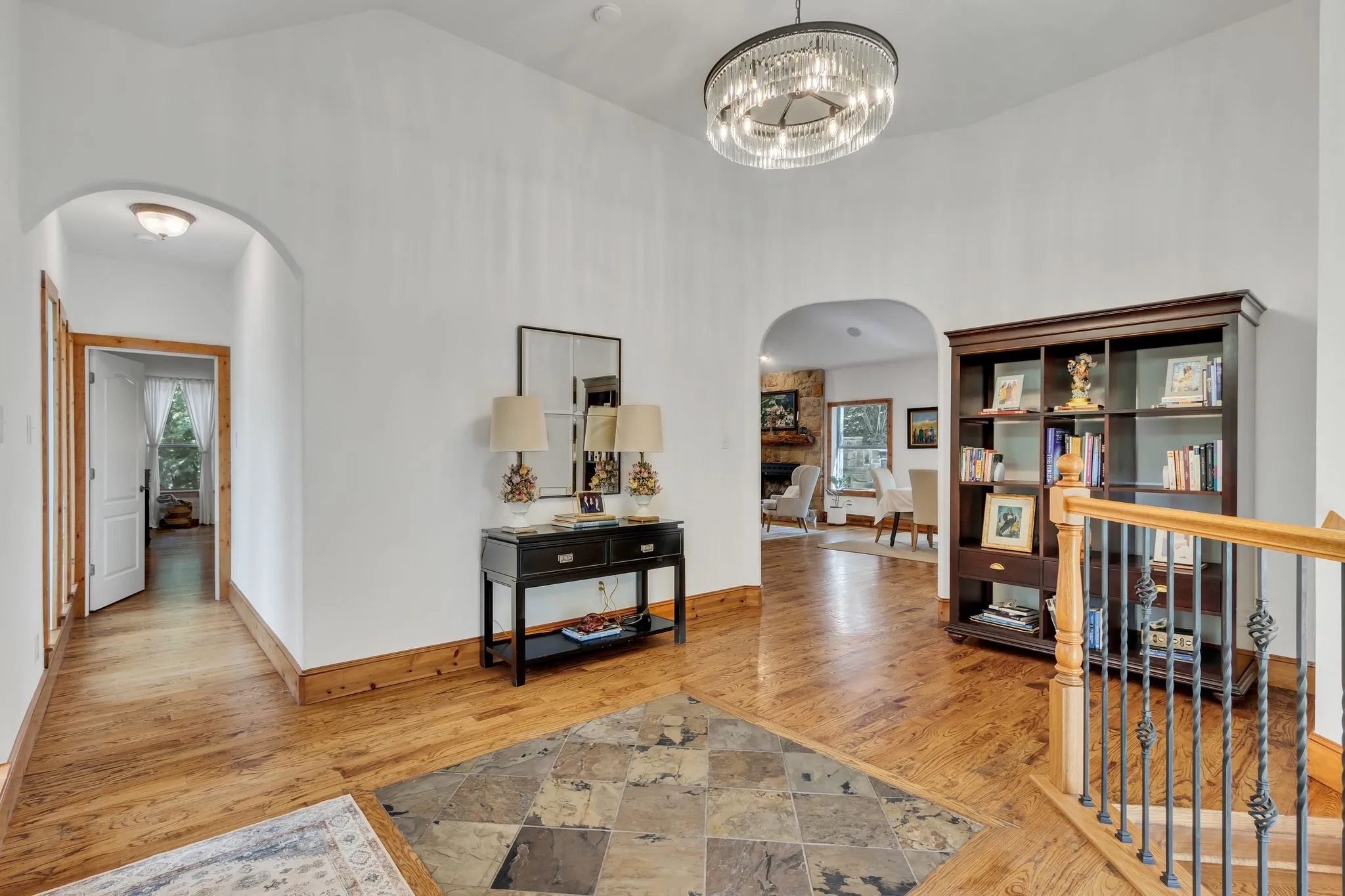 Entry foyer featuring wood-finish flooring, a central tile inlay, and high ceilings