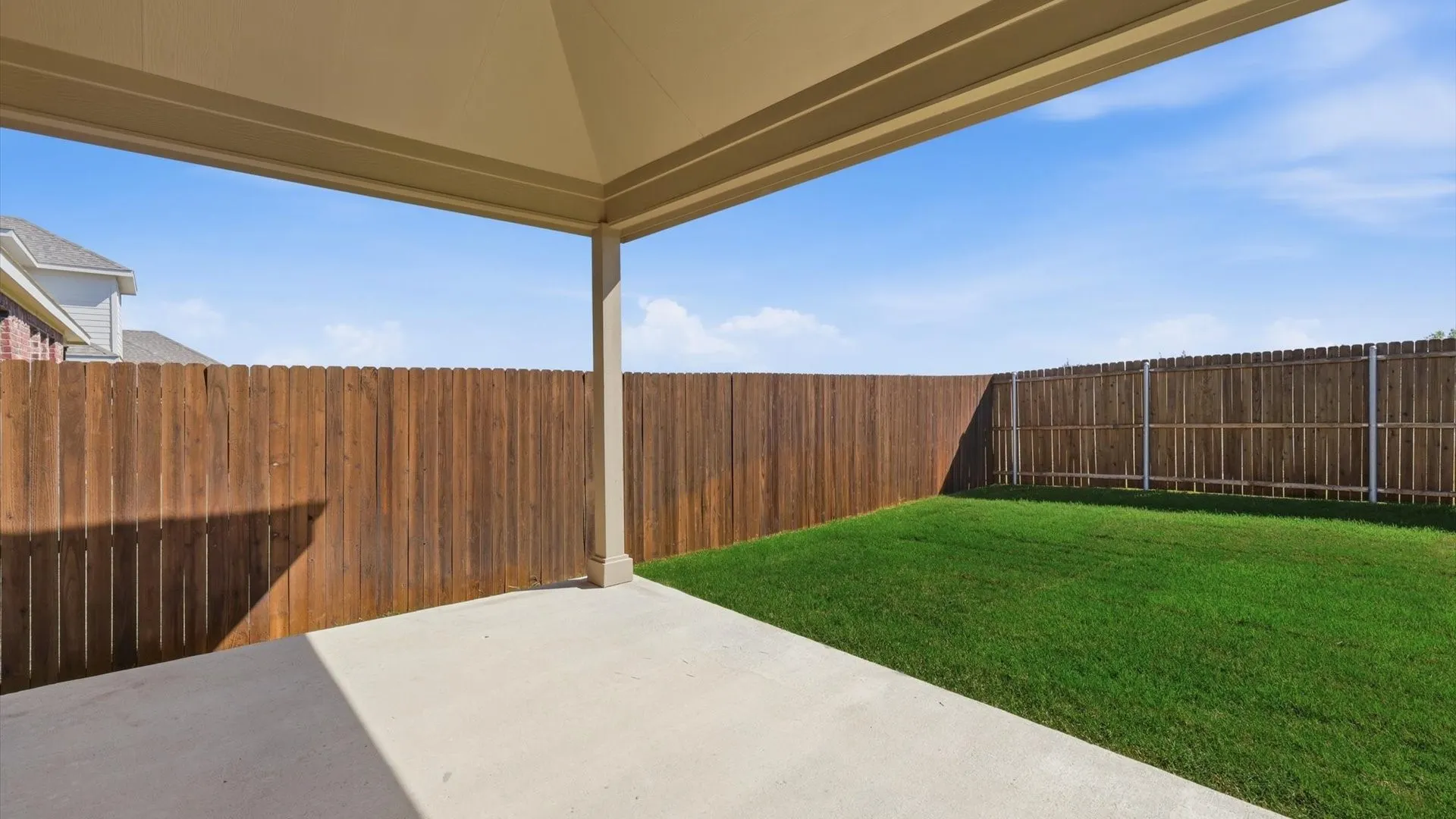 Covered patio with a concrete surface, providing ample outdoor living space