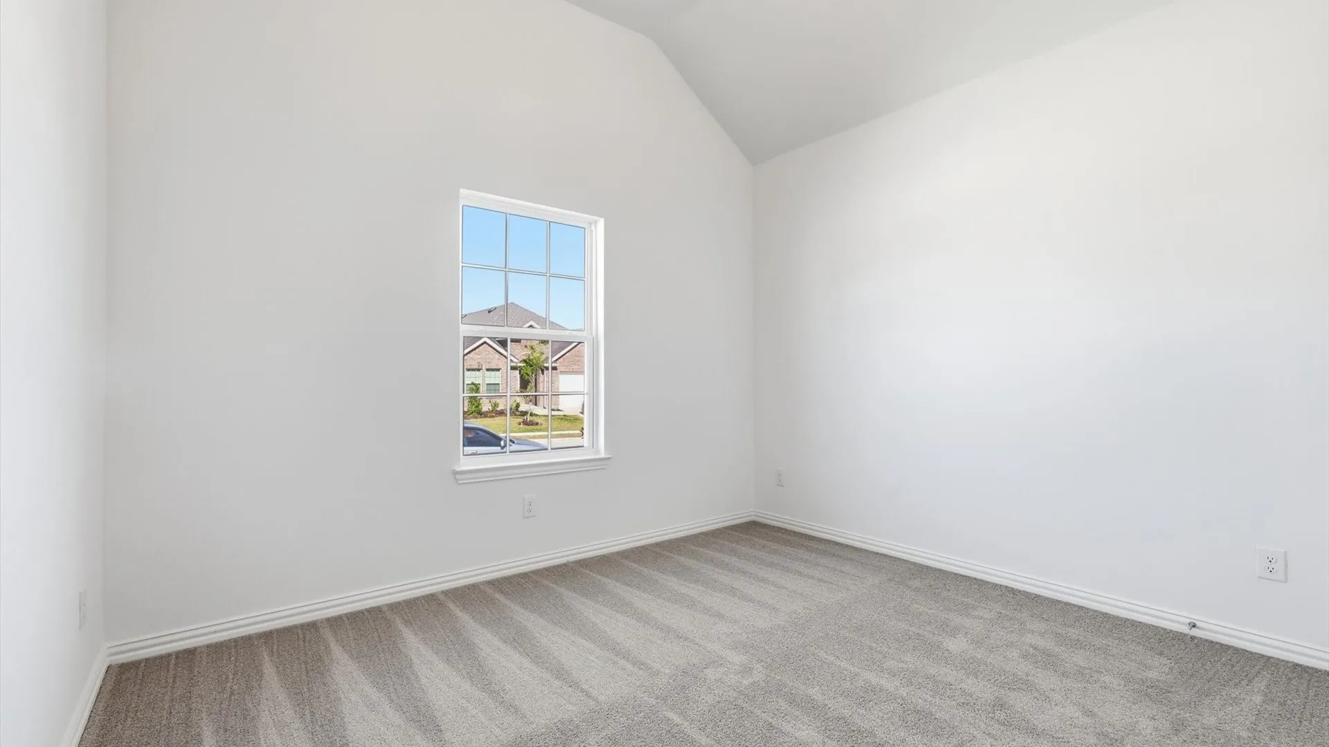 Interior room featuring a vaulted ceiling and a single window with grid panes