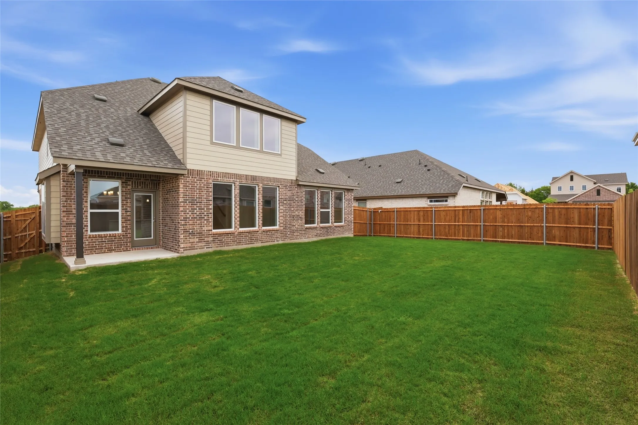 Expansive green lawn with a privacy fence
