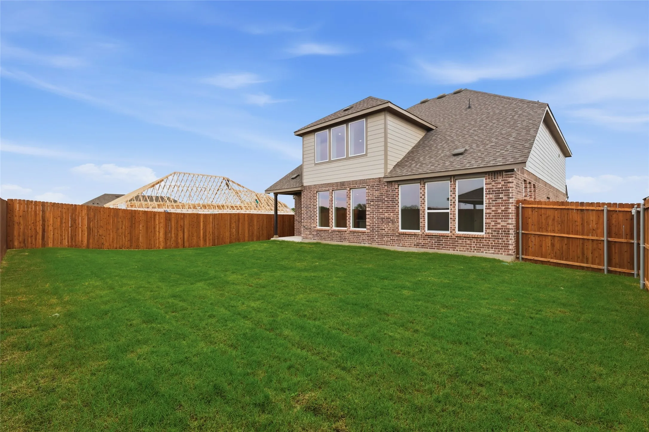 Expansive grassy backyard featuring a full privacy fence