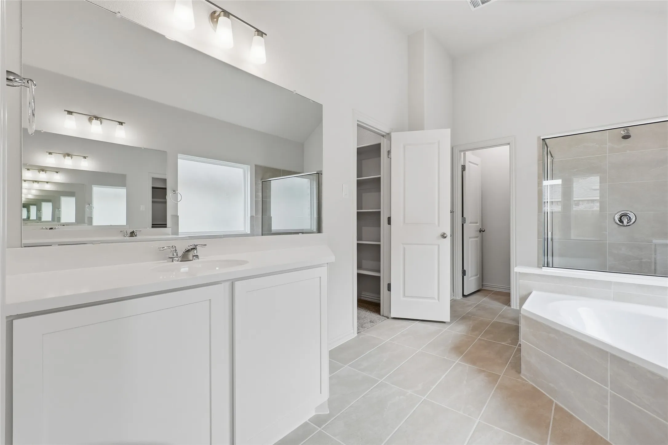 Modern bathroom featuring a single vanity with white cabinetry and a large mirror