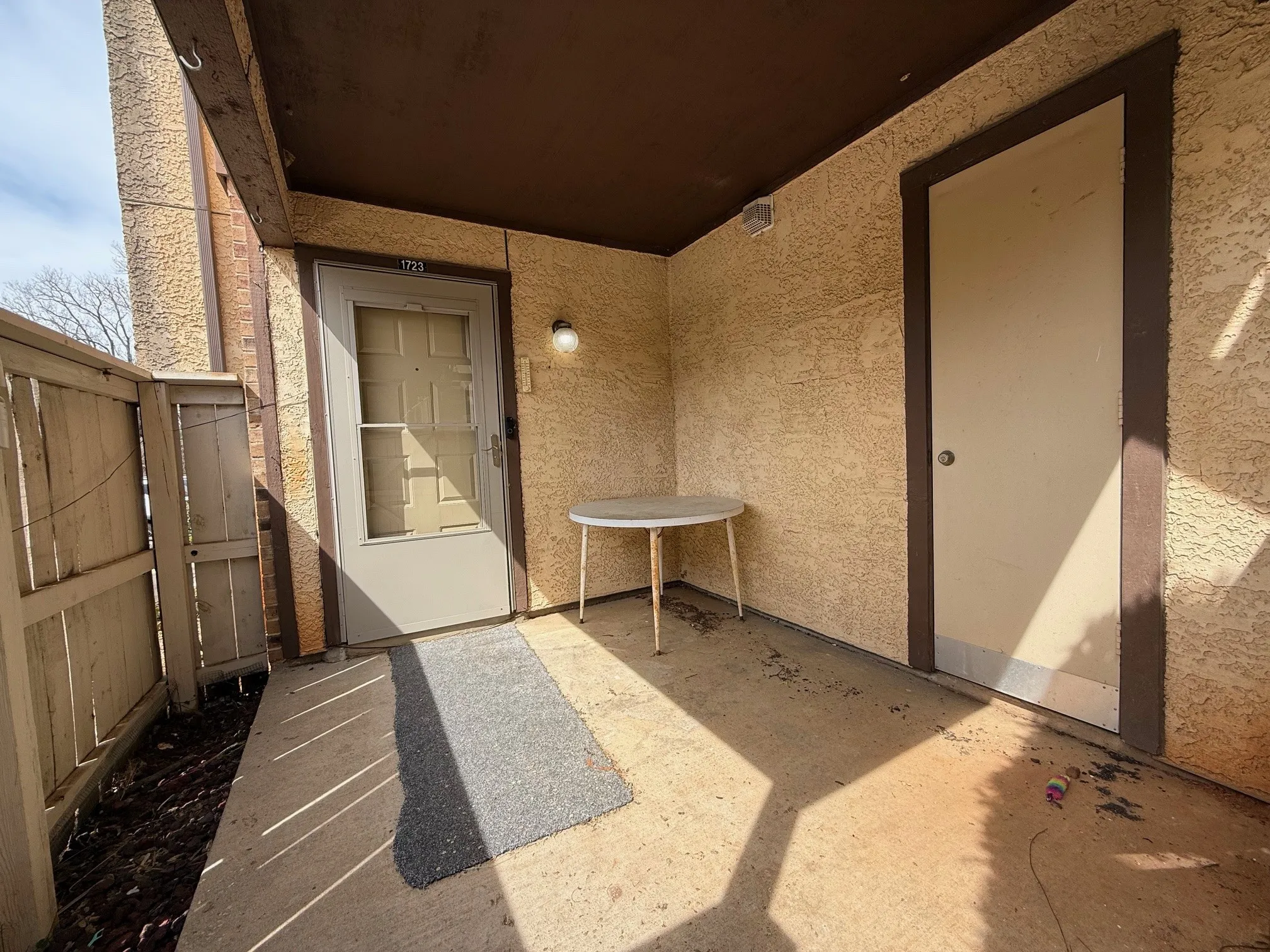 View of exterior entry with stucco siding and a patio area