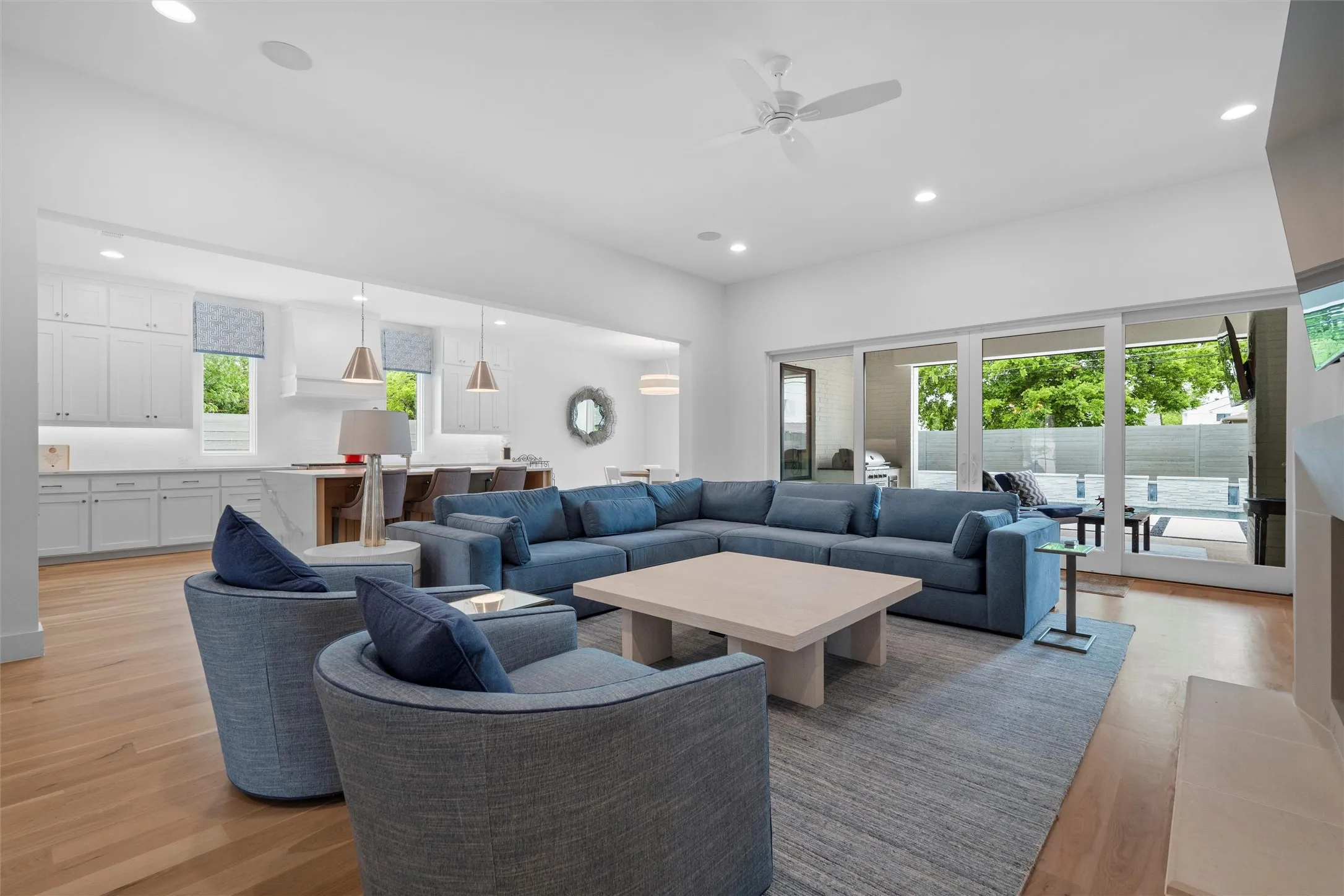 Living room featuring ceiling fan and light hardwood / wood-style floors with double large patio doors leading to outside patio and amazing pool area!