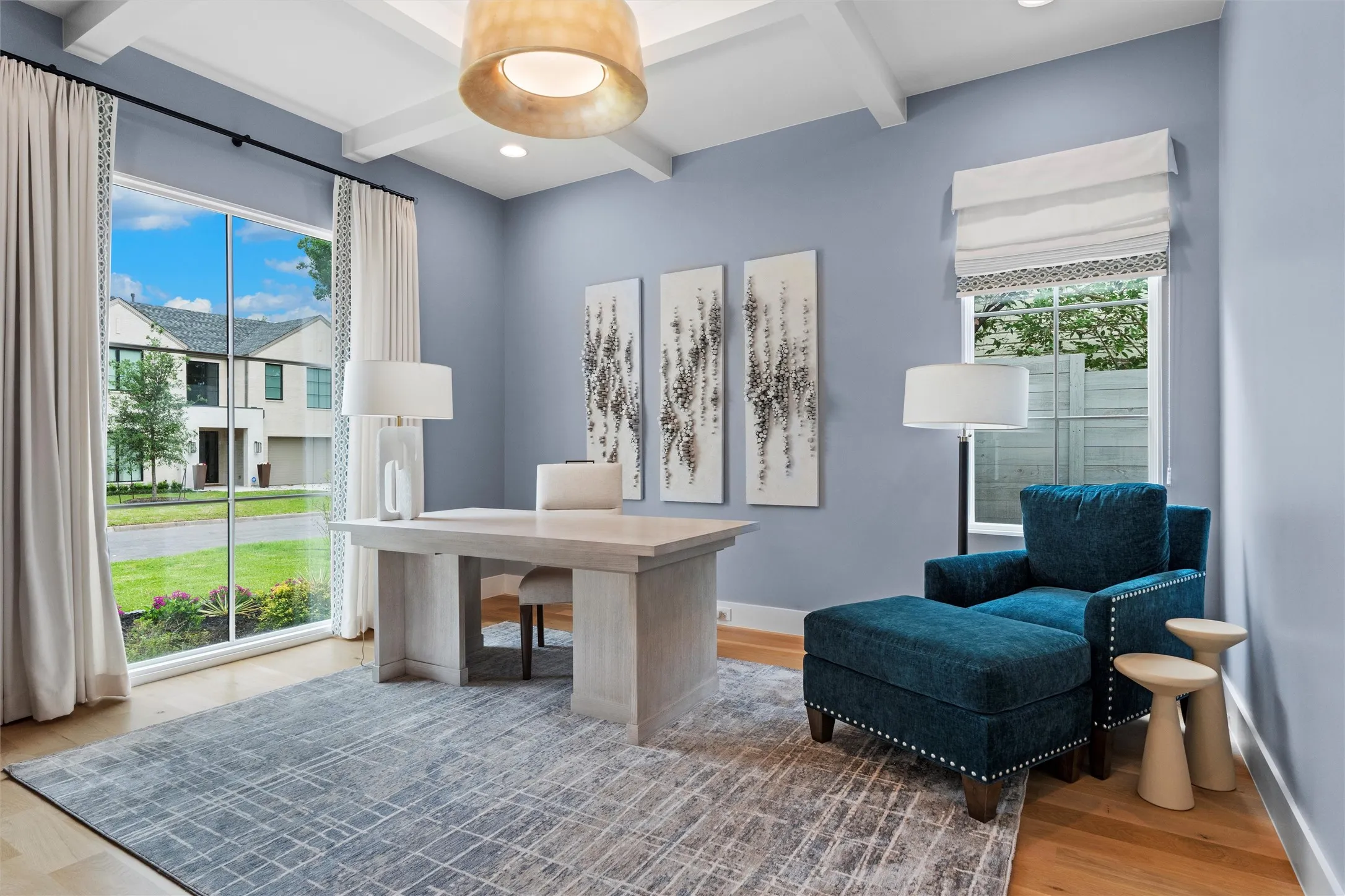 Home office featuring hardwood / wood-style floors, beamed ceiling, and abundant natural light through large windows.