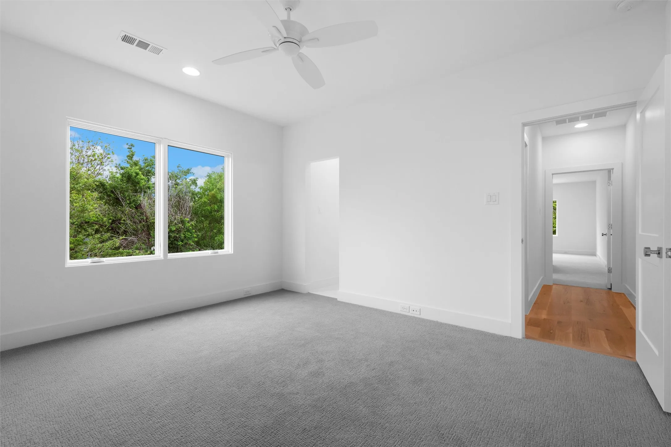 Secondary bedroom on second floor featuring ceiling fan, dark carpeting and large windows for amazing natural light.