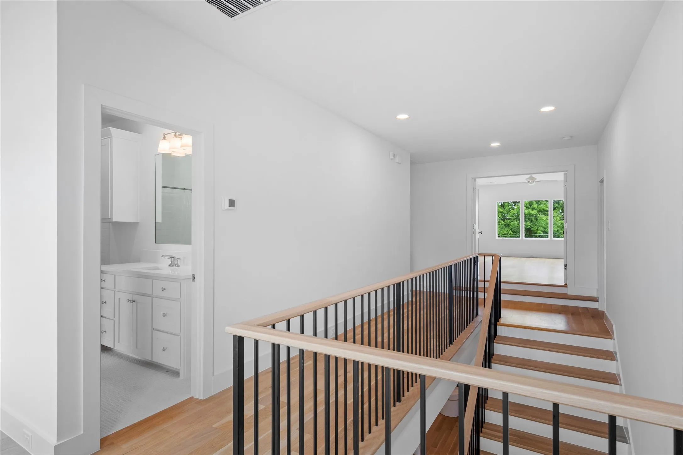 Second floor landing, featuring access to full bath, game room, bedrooms and exercise room.  Corridor featuring light hardwood / wood-style flooring.