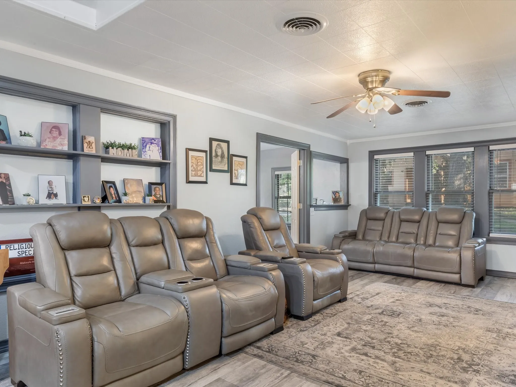 Cinema room featuring wood finished floors, ceiling fan, and crown molding