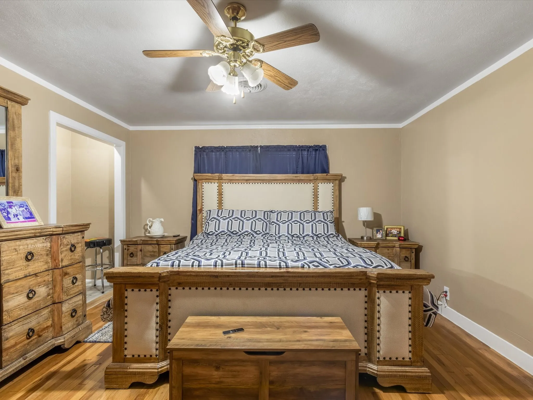 Bedroom with wood finished floors, a ceiling fan, and ornamental molding